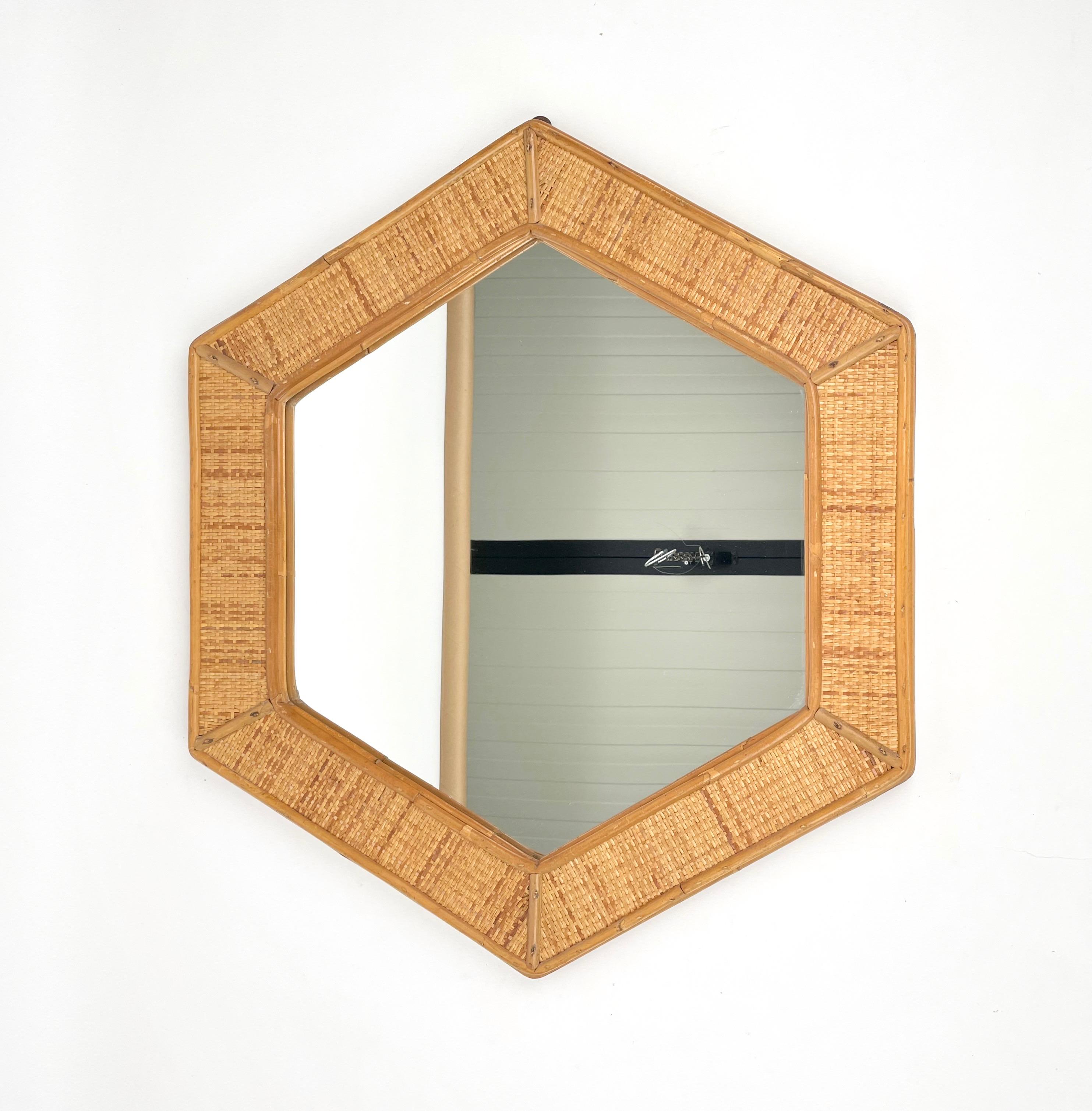 Hexagonal wall mirror featuring rattan frame. Made in Italy in the 1970s.