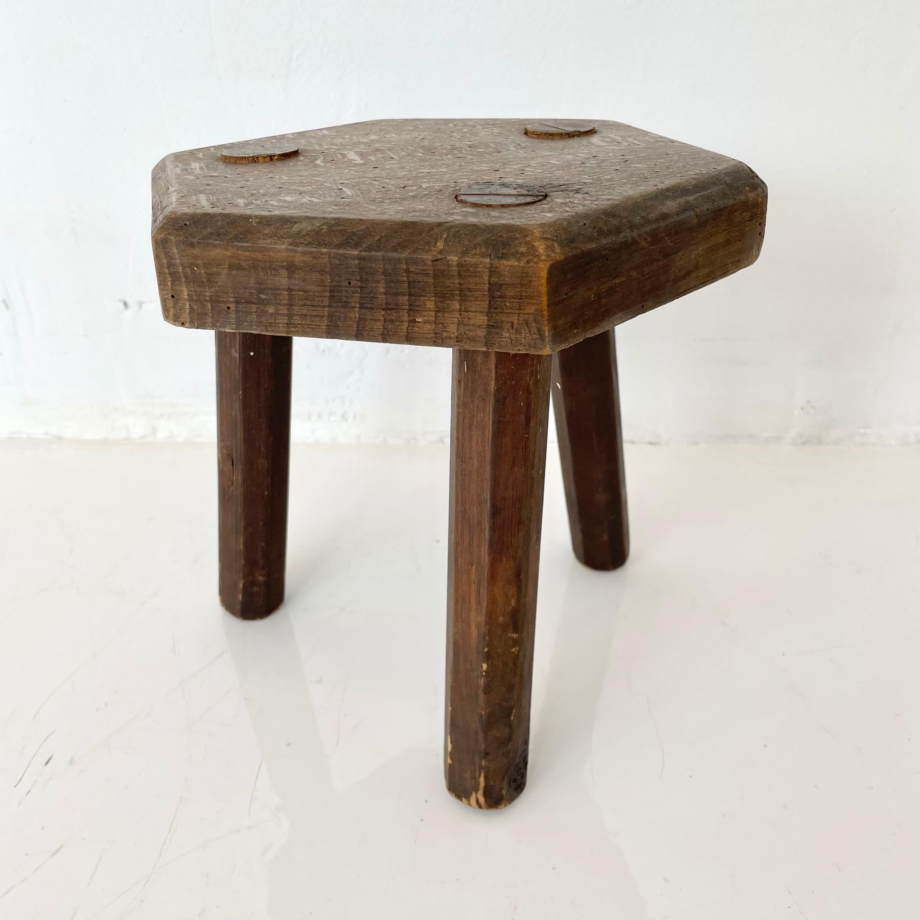 Stubby wooden hexagonal stool, made in France, circa 1950s. Thick seat with three rounded legs. No nails or hardware. Great lines and shape. Petite stool with great presence. Great vintage condition. Perfect for books or objects. 
     