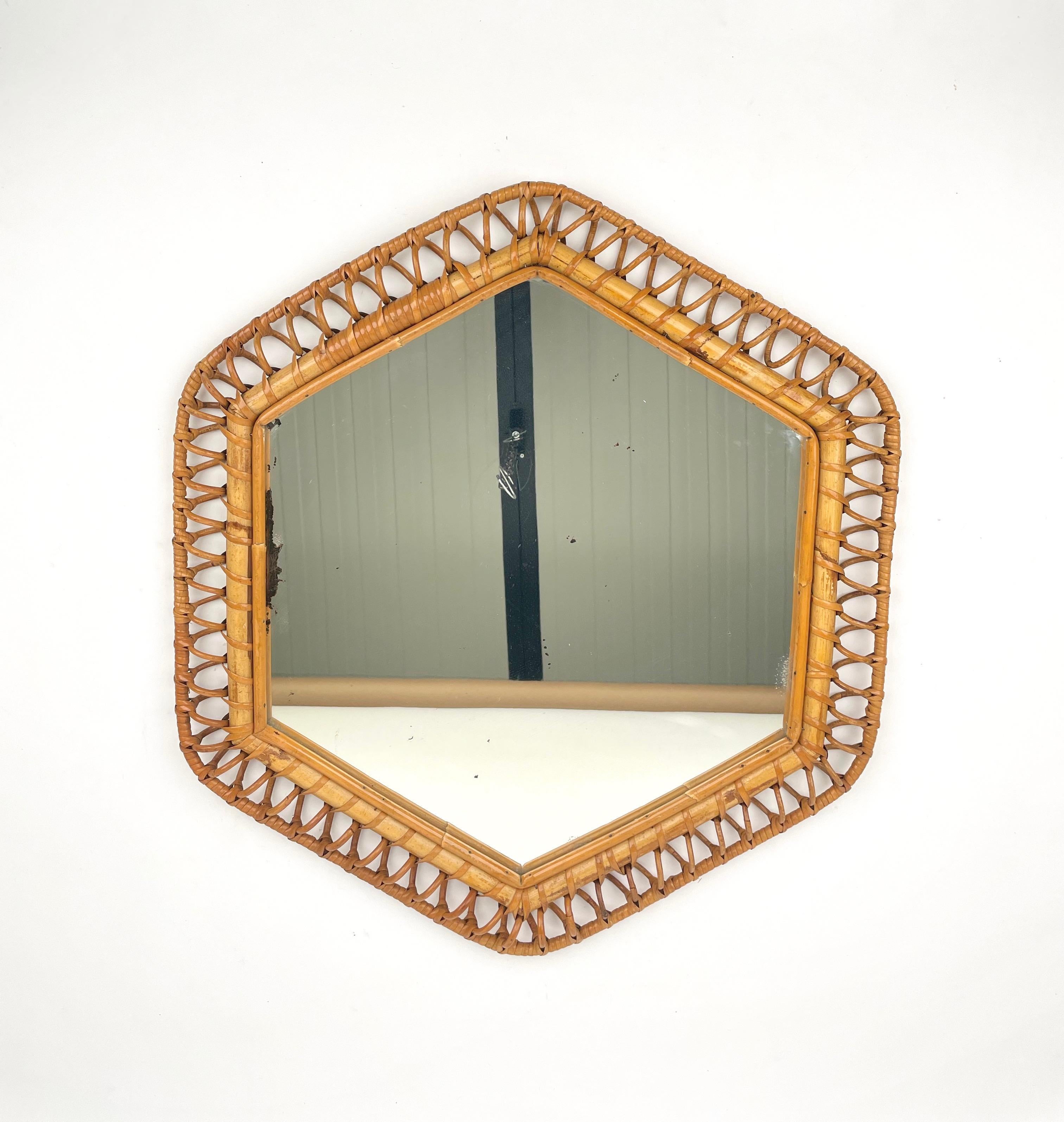 Hexagonal wall mirror featuring bamboo frame surrounded by elegant wicker spirals.

Made in Italy in the 1960s.
