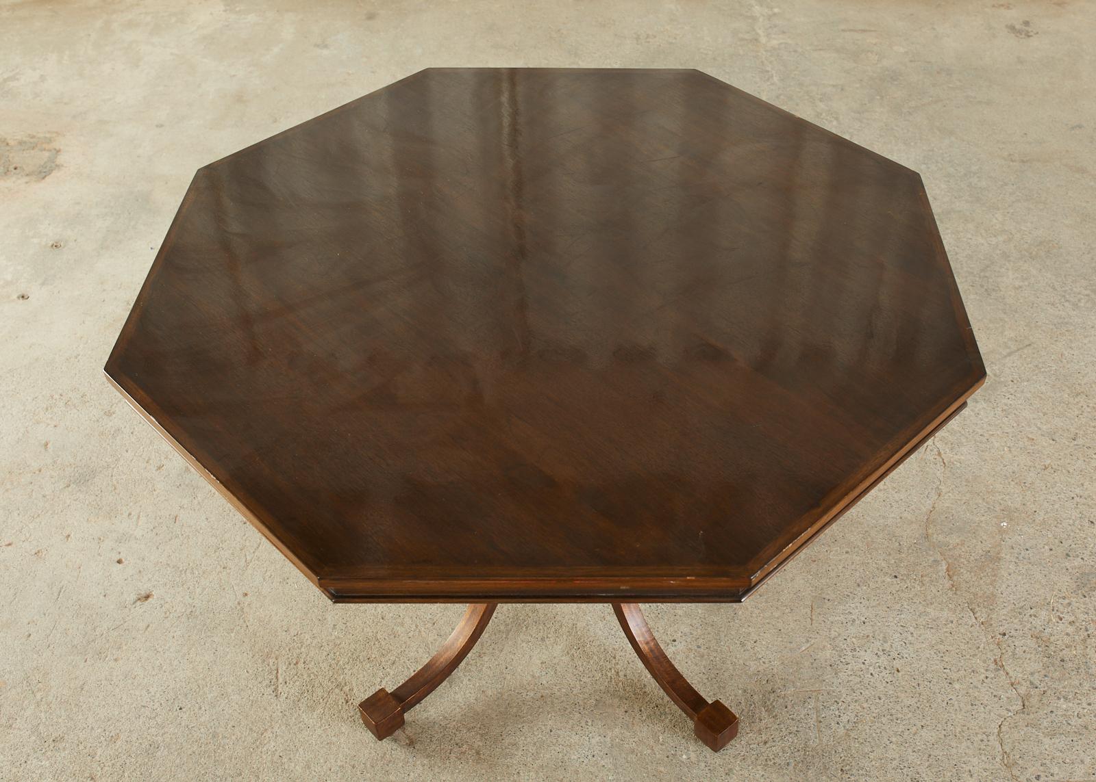 Unique walnut and iron dining table or center table featuring a hexagonal shaped top. Bespoke table made by Murrays ironworks foundry in Los Angeles, CA for an estate in Bel Air, CA. The wood top is supported by four gracefully curved square iron