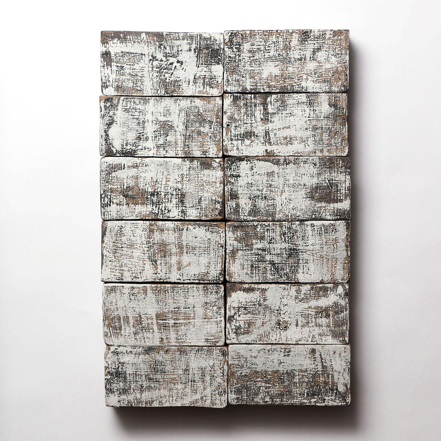 Based on the I Ching, an ancient Chinese divination text, this one-of-kind ceramic wall sculpture is composed of handmade stoneware blocks. Each block has a complex layered black and white finish, with a texture reminiscent of wood or stone, and is