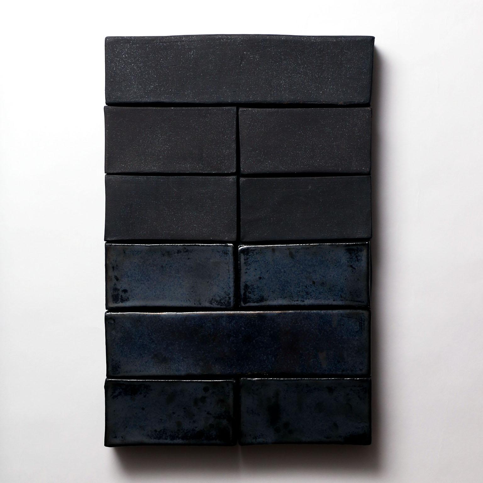Based on the I Ching, an ancient Chinese divination text, this one-of-kind ceramic wall sculpture is composed of handmade stoneware blocks. Each block is individually finished with either a metallic black matte finish or a glossy iridescent black