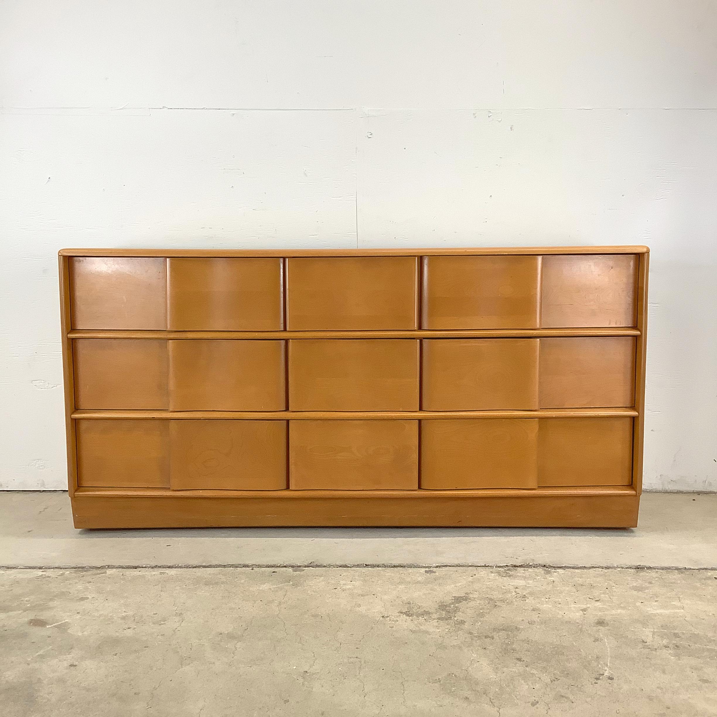 Step into mid-century sophistication with this Heywood Wakefield Nine-Drawer Dresser in a gorgeous champagne finish. A perfect mix of elegance and practicality, this dresser features sculptural drawer fronts that add visual depth to its minimalist