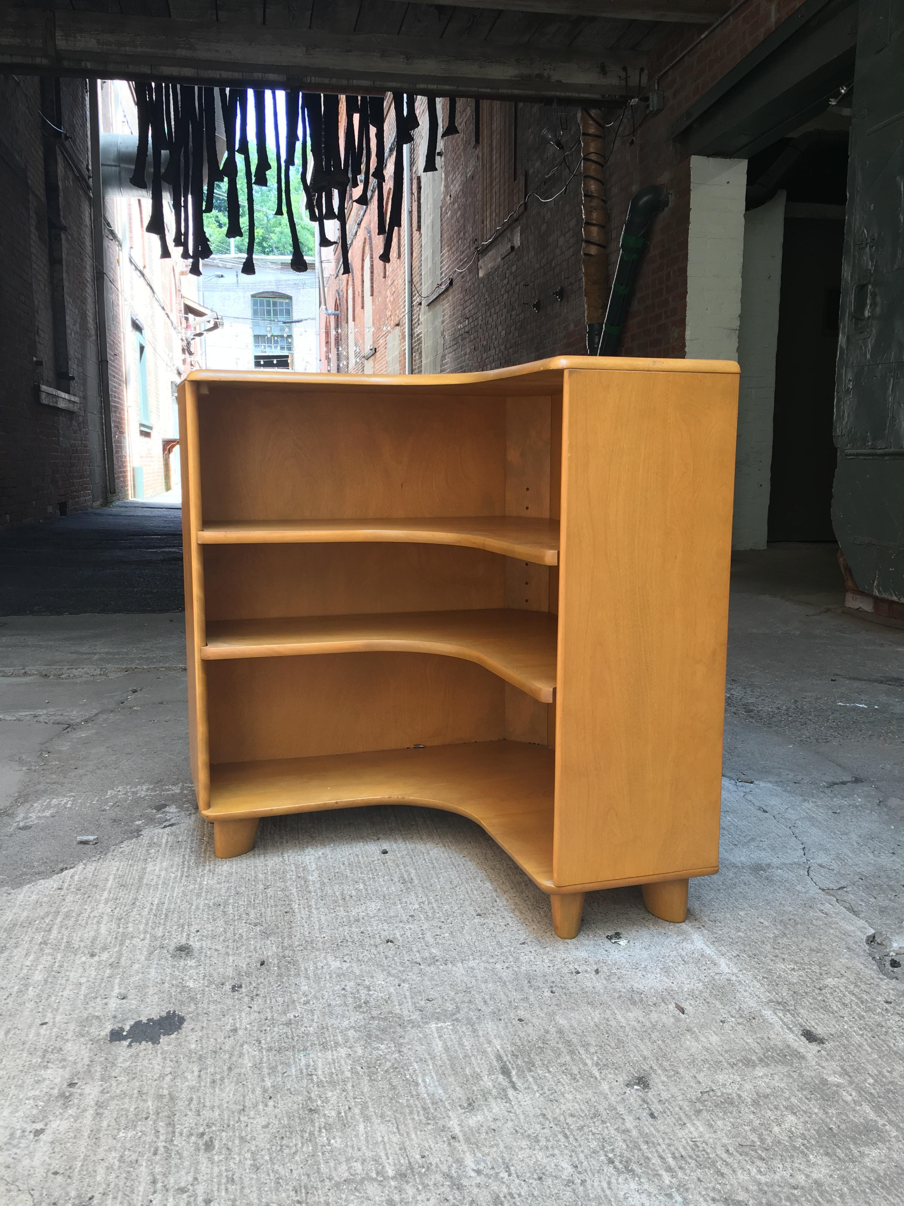 Heywood Wakefield corner bookcase in Wheat finish. C3971. Solid Maple construction. Very good original finish with minor finish loss on one shelf. Illegible date stamp on the back possibly March, 21, 1955.

Measures: 28