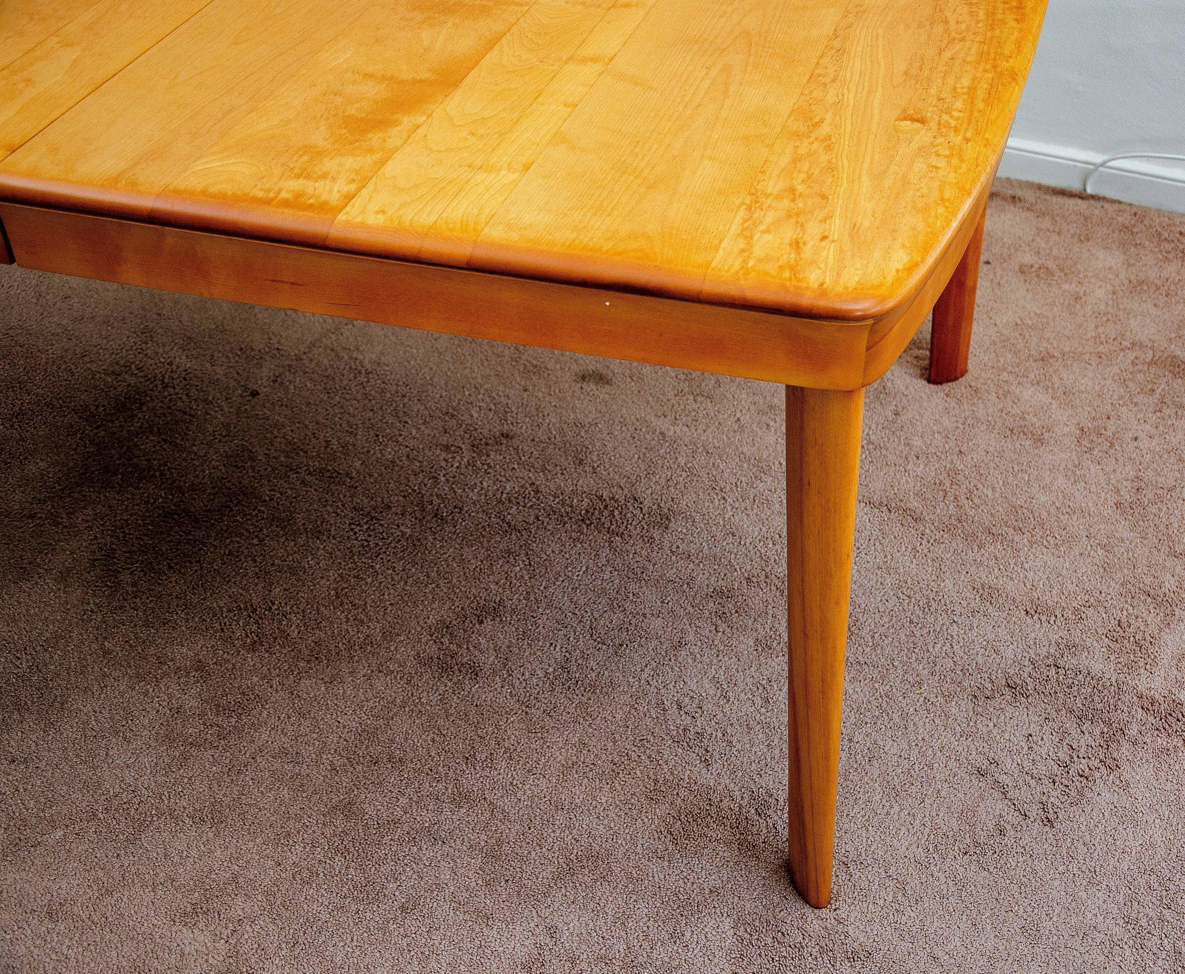 Nice solid birch dining table manufactured and dated May 5, 1949. Easy seating for six people without leaf and eight people with the leaf in place. The table was acquired from the original owner who custom ordered it with just one leaf and no center