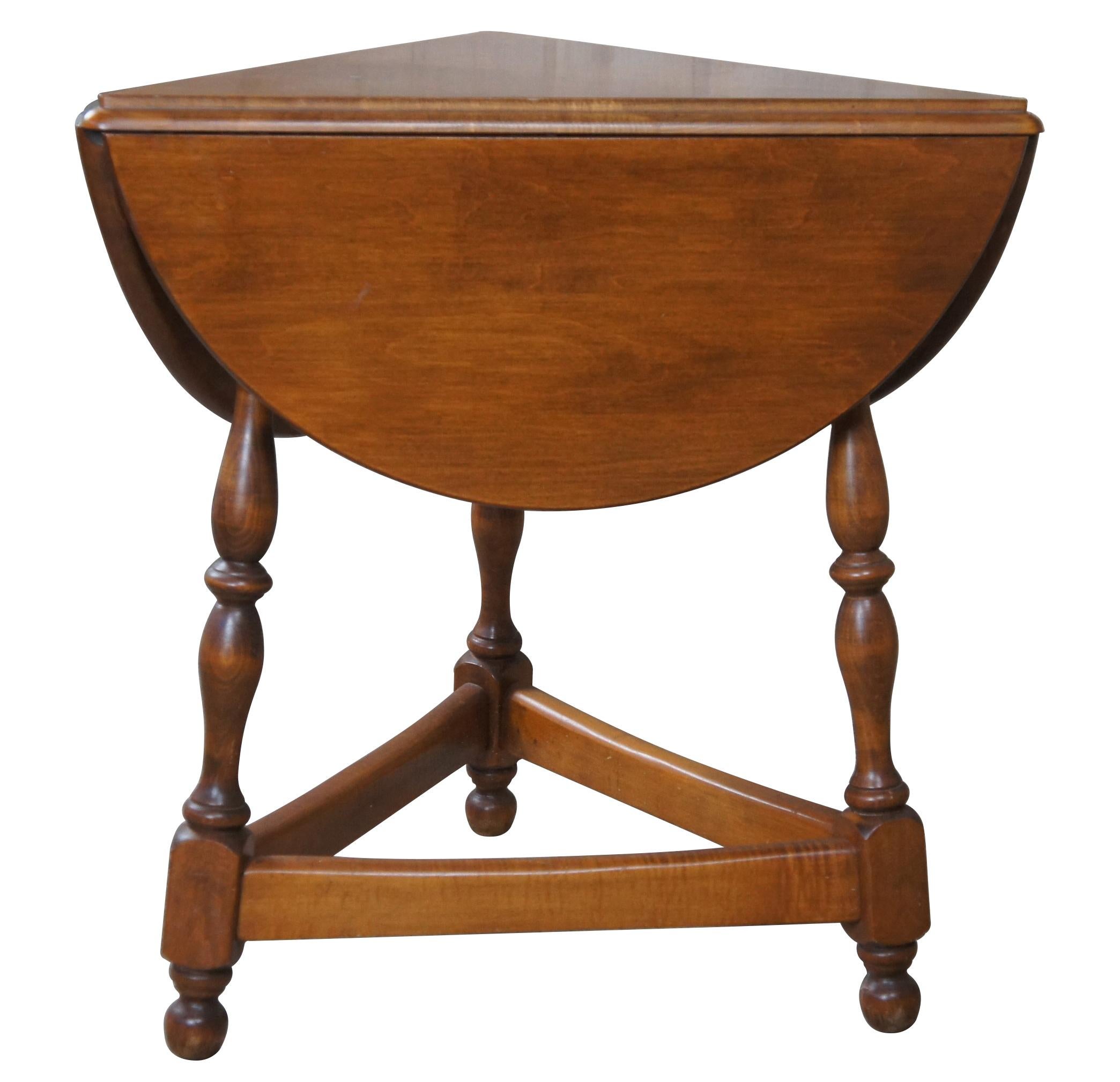 Heywood Wakefield cloverleaf side table 226-08, cinnamon finish. Made from maple with a triangular form over turned spindle legs and bun feet connected by stretchers.
