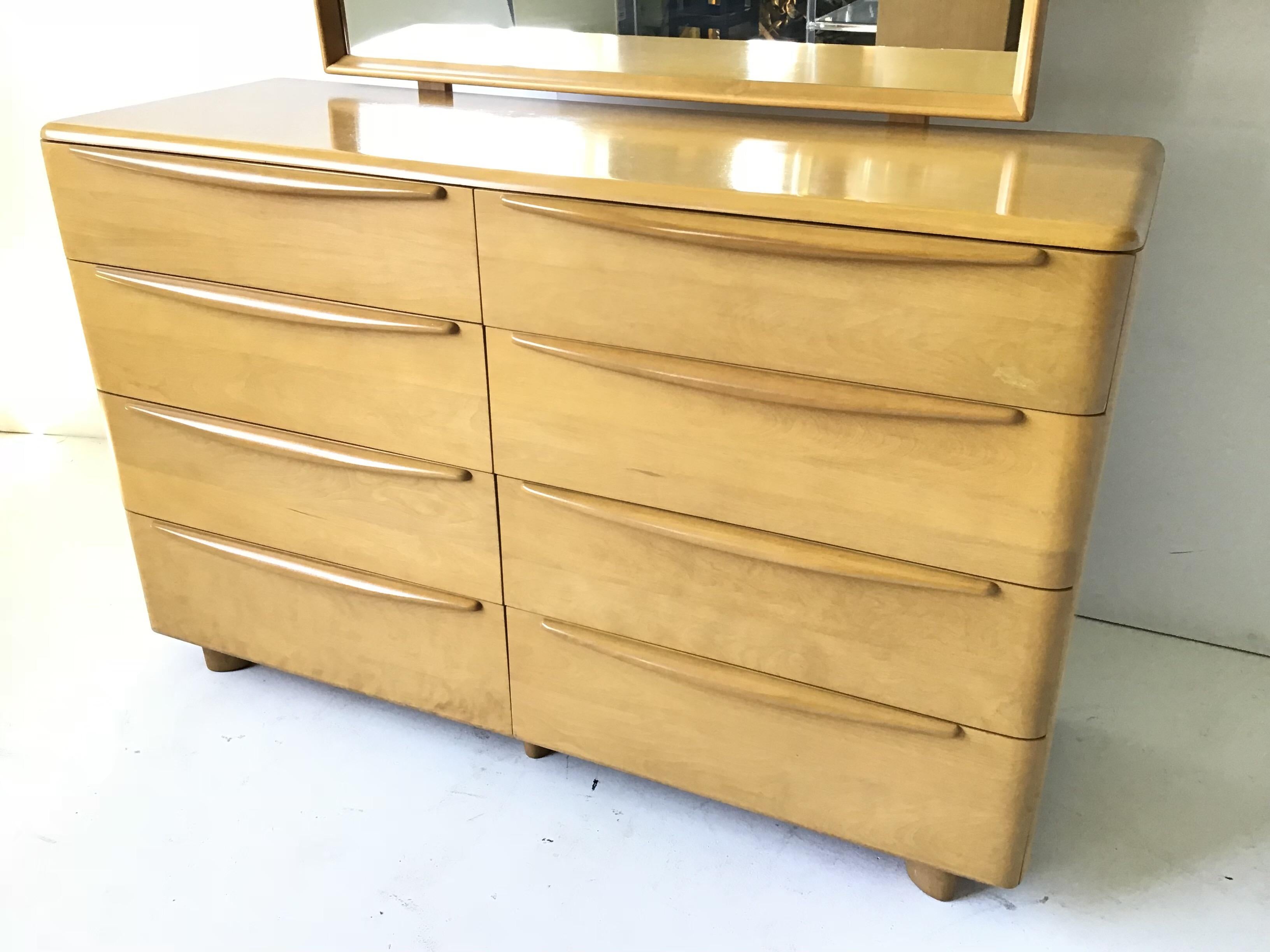 This is a very clean original version of a hard to find 8-drawer dresser by Heywood Wakefield. It is in the encore pattern. It has a mirror. It is original wheat finish! Measures: Height with mirror is 64