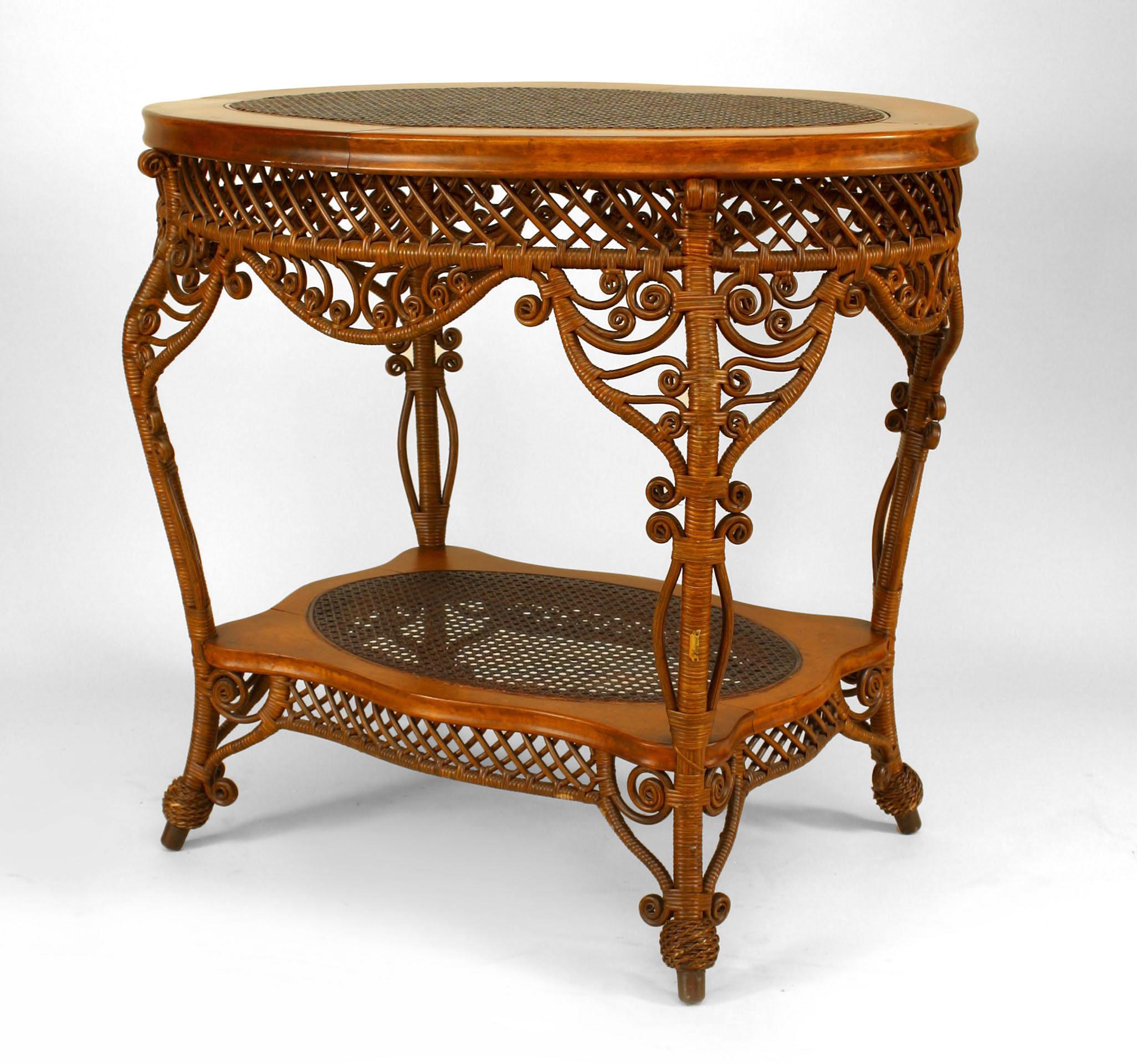 American Victorian natural wicker oval center table with woven top and shelf with filigree & scroll trim apron (HEYWOOD WAKEFIELD paper label).

