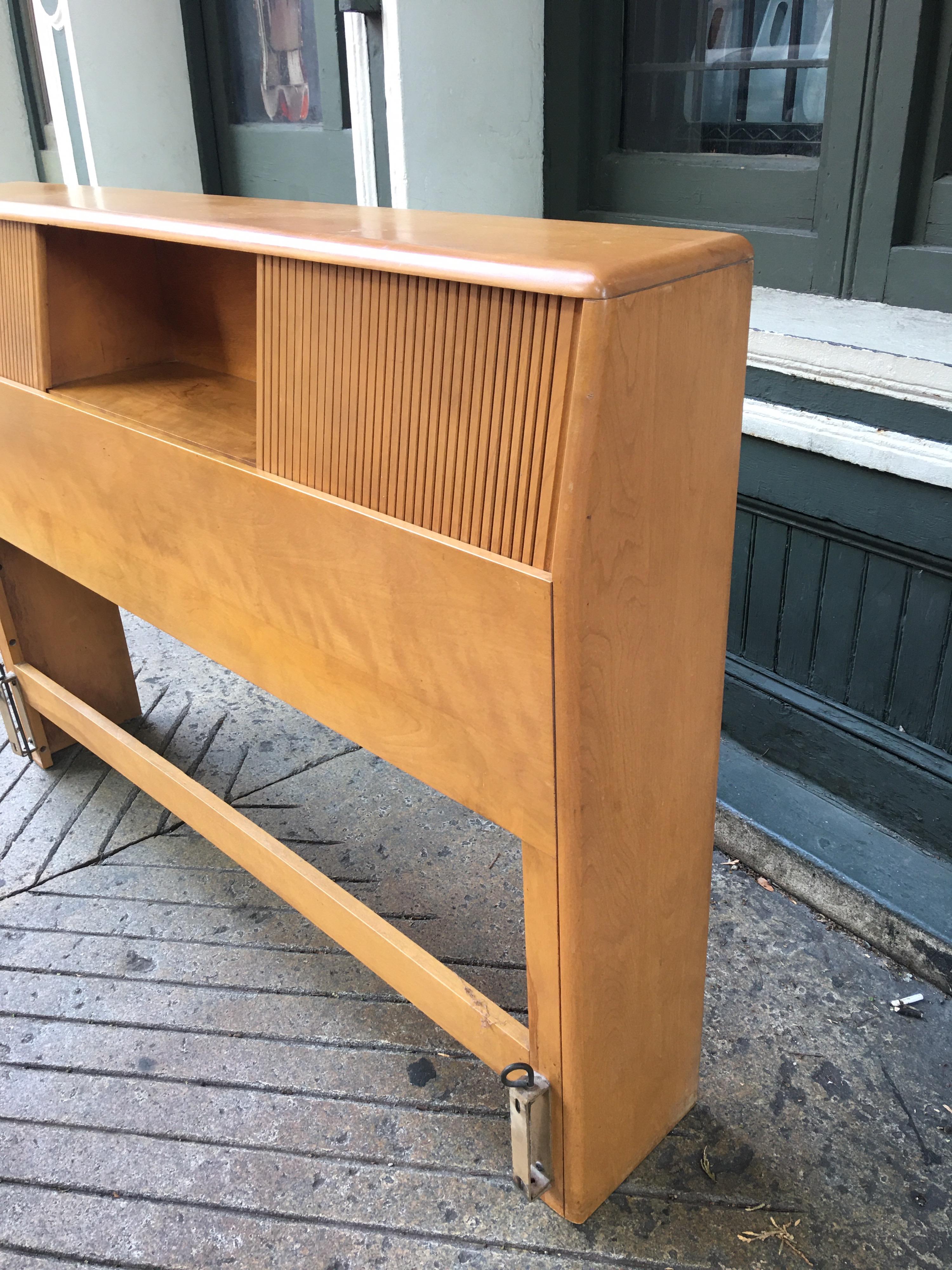 Heywood Wakefield solid maple full size headboard. Original Champagne finish. Shows some losses to finish, but overall pretty clean. Sliding wood doors conceal storage space at both ends.