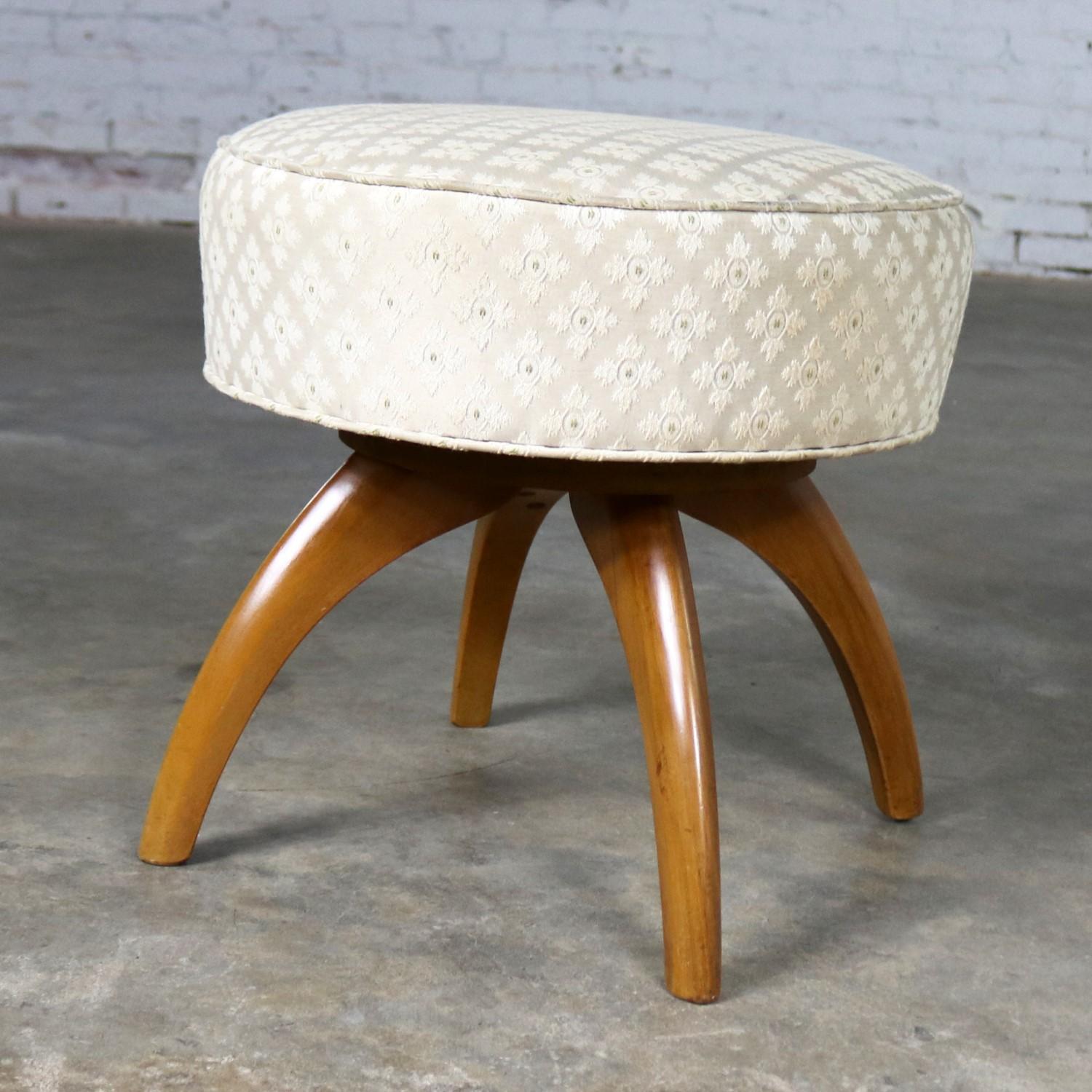 Handsome swivel Heywood-Wakefield round vanity stool or ottoman pouf from their Kohinoor collection and attributed to Ernst Herrmann. It is in wonderful vintage condition. The beautiful original wheat finish on the legs is not flawless but almost.