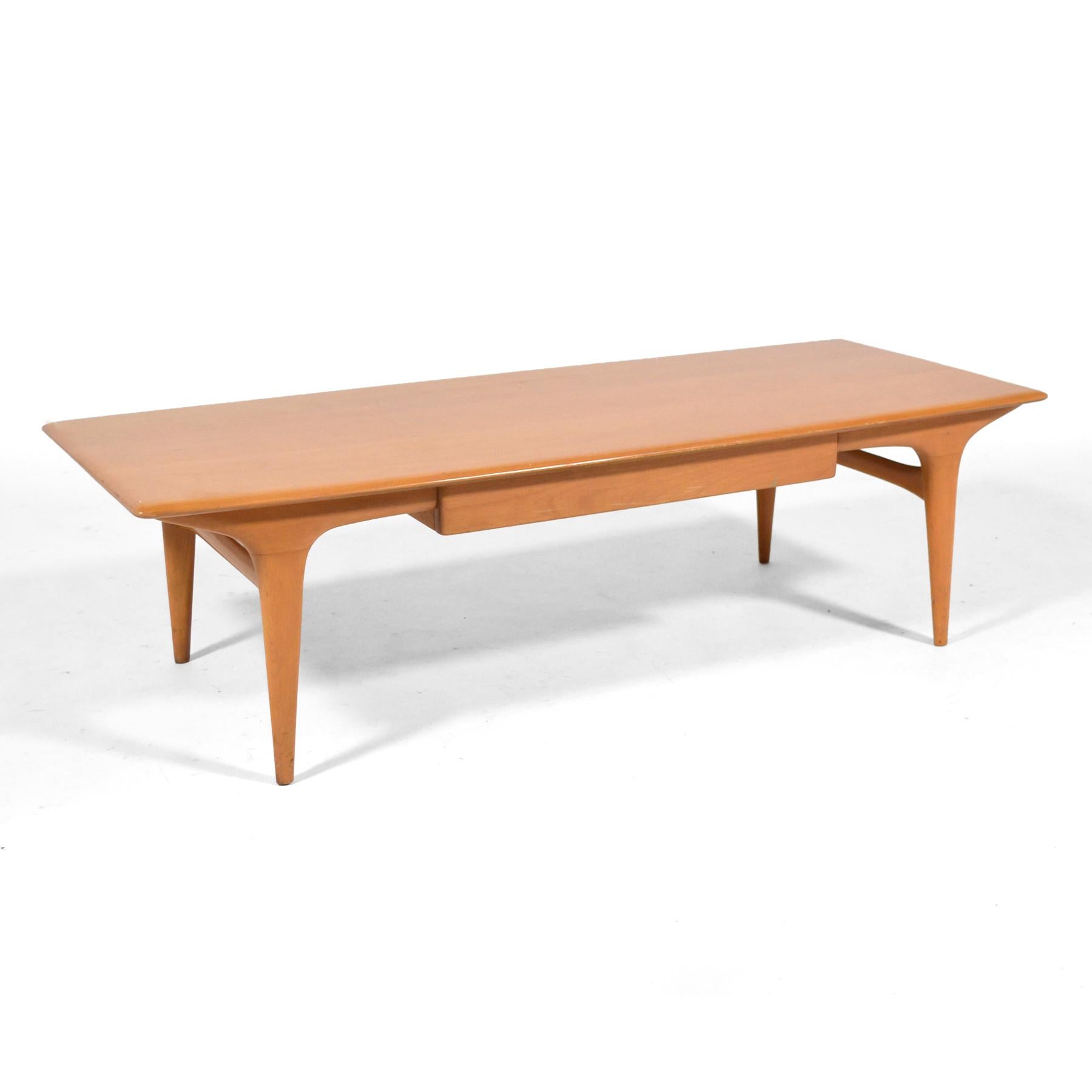 This rare Heywood Wakefield model M1585 coffee table is not just a very uncommon and beautiful form, it is in fantastic original condition including its champaign finish. The design was only produced between 1956 and 1958.