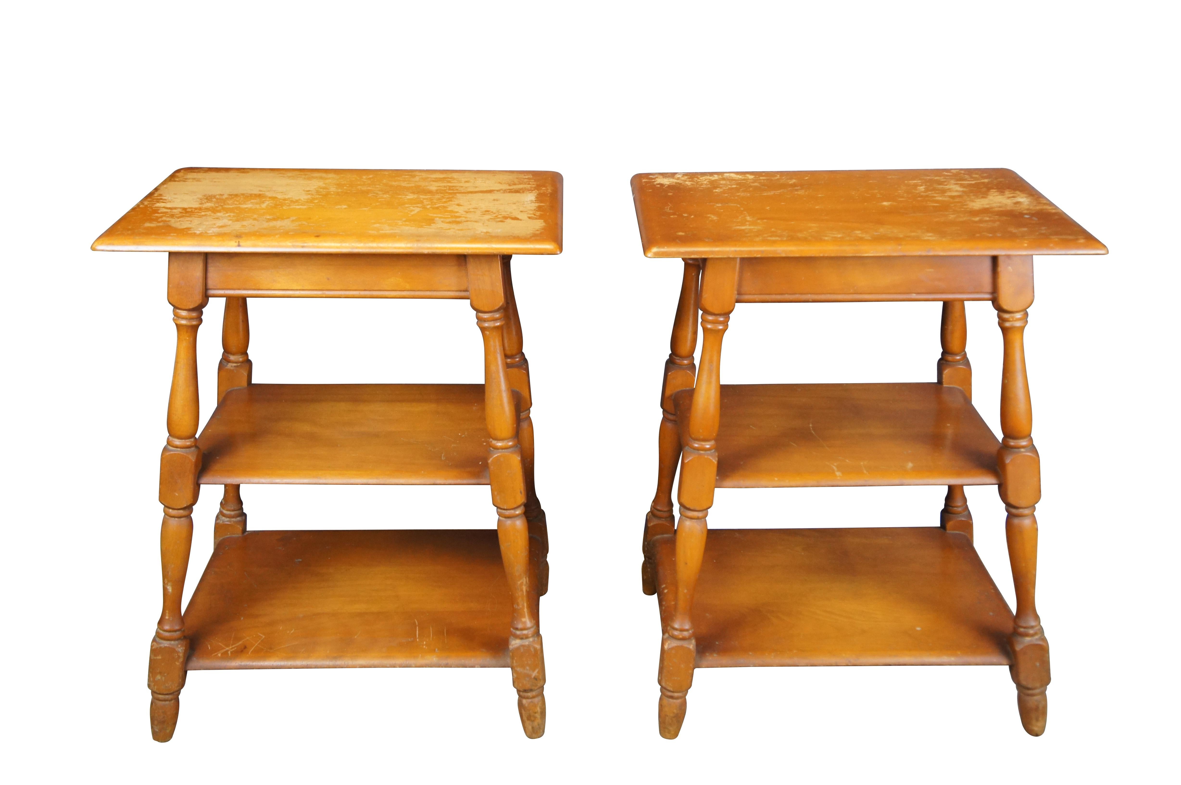 Rare pair of mid century modern Heywood Wakefield side tables / plant stands / nightstands.  Made of maple featuring rectangular tapered form with three tiers and turned legs.  

The Heywood Brothers furniture company formed in 1826 in Massachusetts
