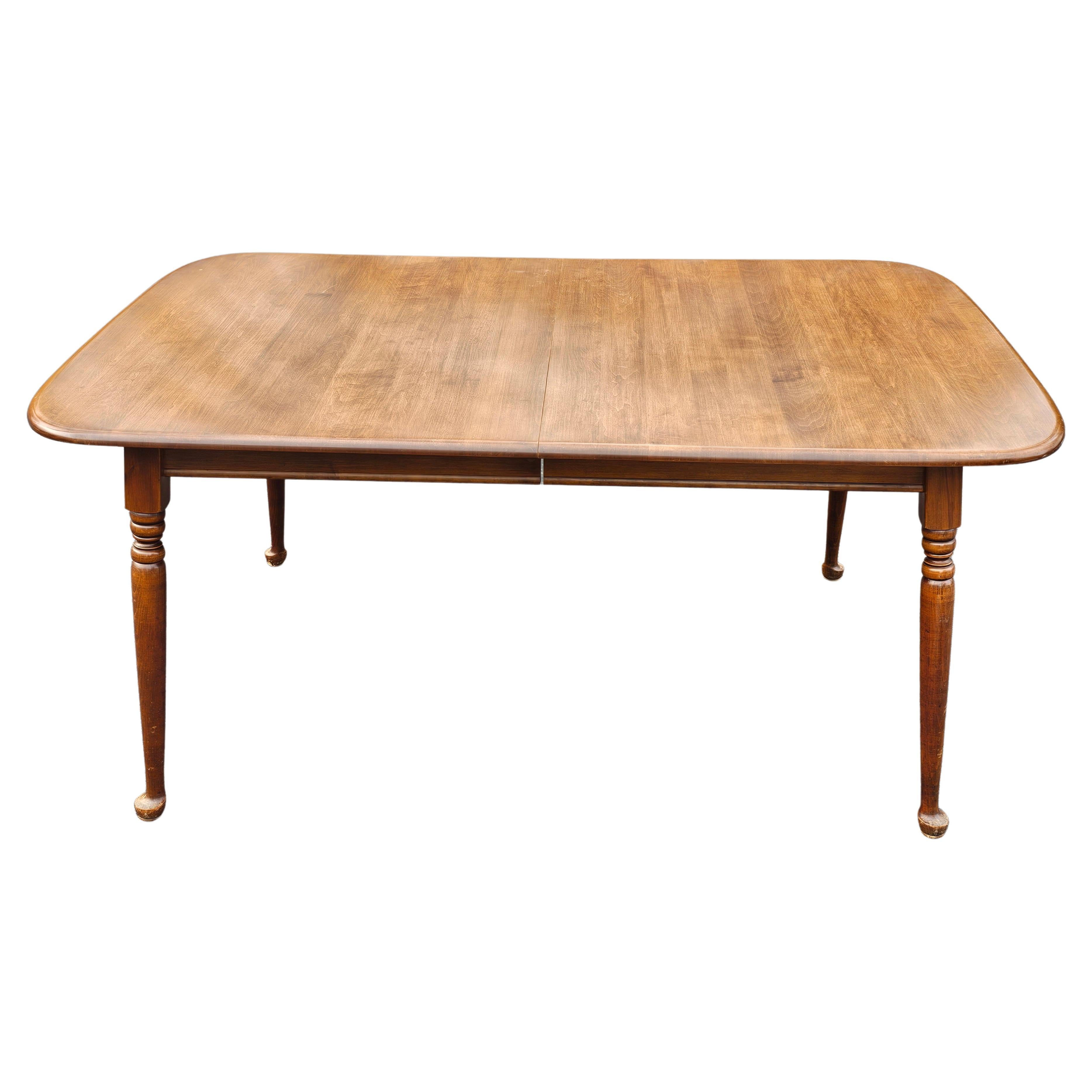 A Heywood Wakefield solid Maple Cinnamon Colonial Style 3-leaf extension dining table with Watertown Slide extension mechanism. Top in great condition. Come with protective pads. Virtually scratch free. Very good vintage condition. Measures 64