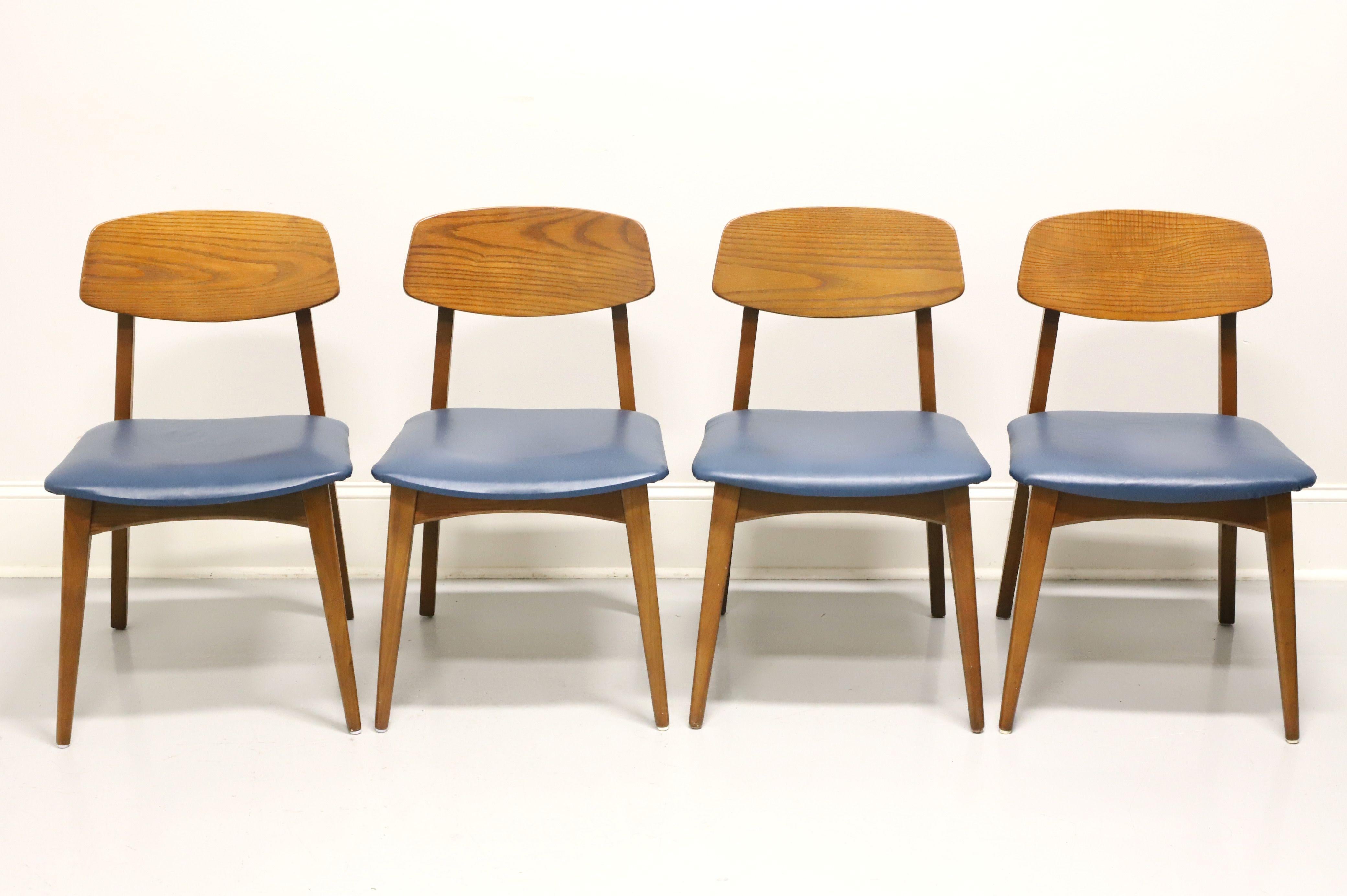 A set of four Mid 20th Century Modern dining side chairs by Heywood Wakefield. Solid oak with curved backrest, blue vinyl upholstered seat and tapered legs. Made in Gardner, Massachusetts, USA, in the mid 20th Century.

Measures: Overall: 18.5w
