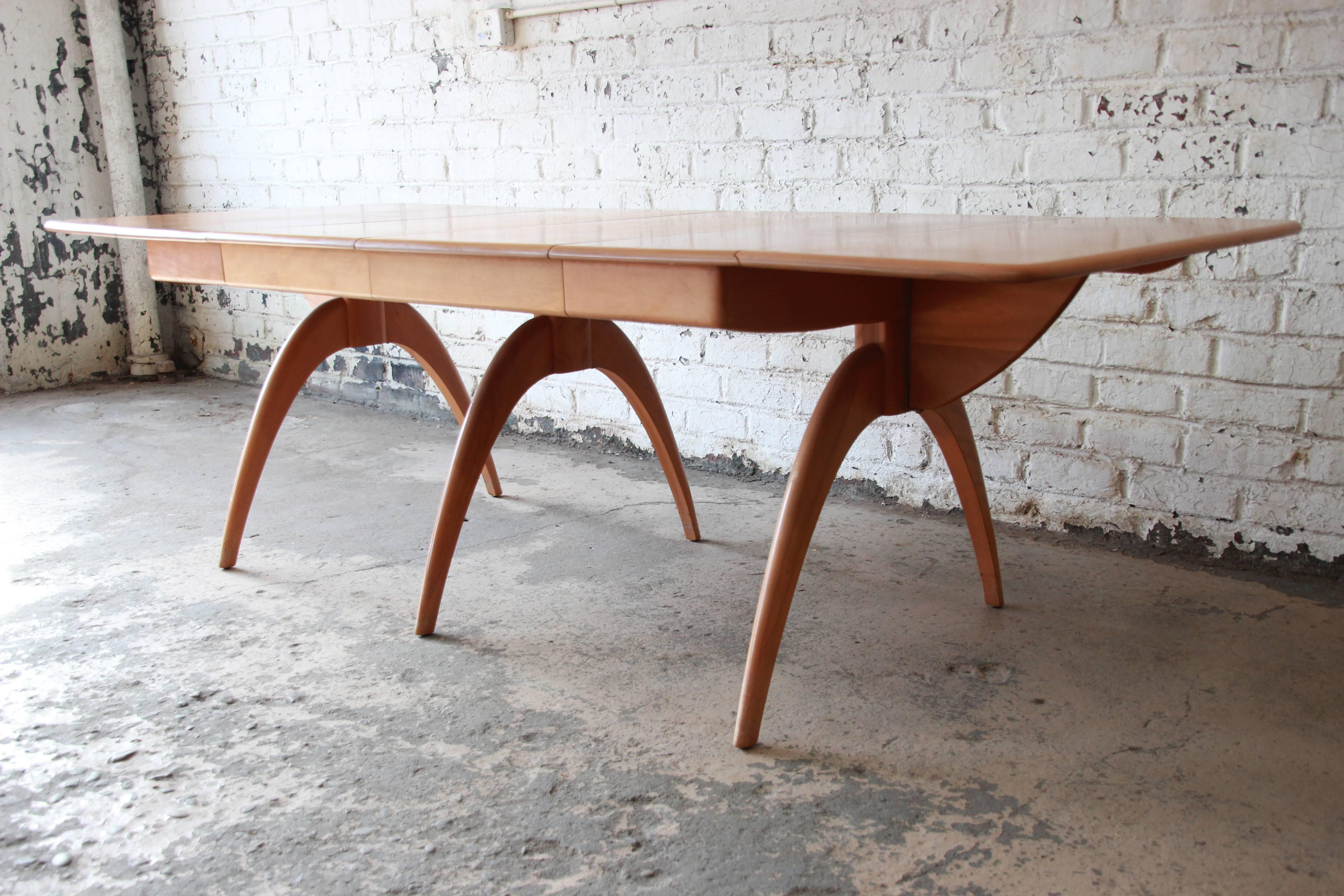 An exceptional Mid-Century Modern extension drop-leaf wishbone dining table by Heywood-Wakefield. The table is well constructed from solid maple and features sculpted 