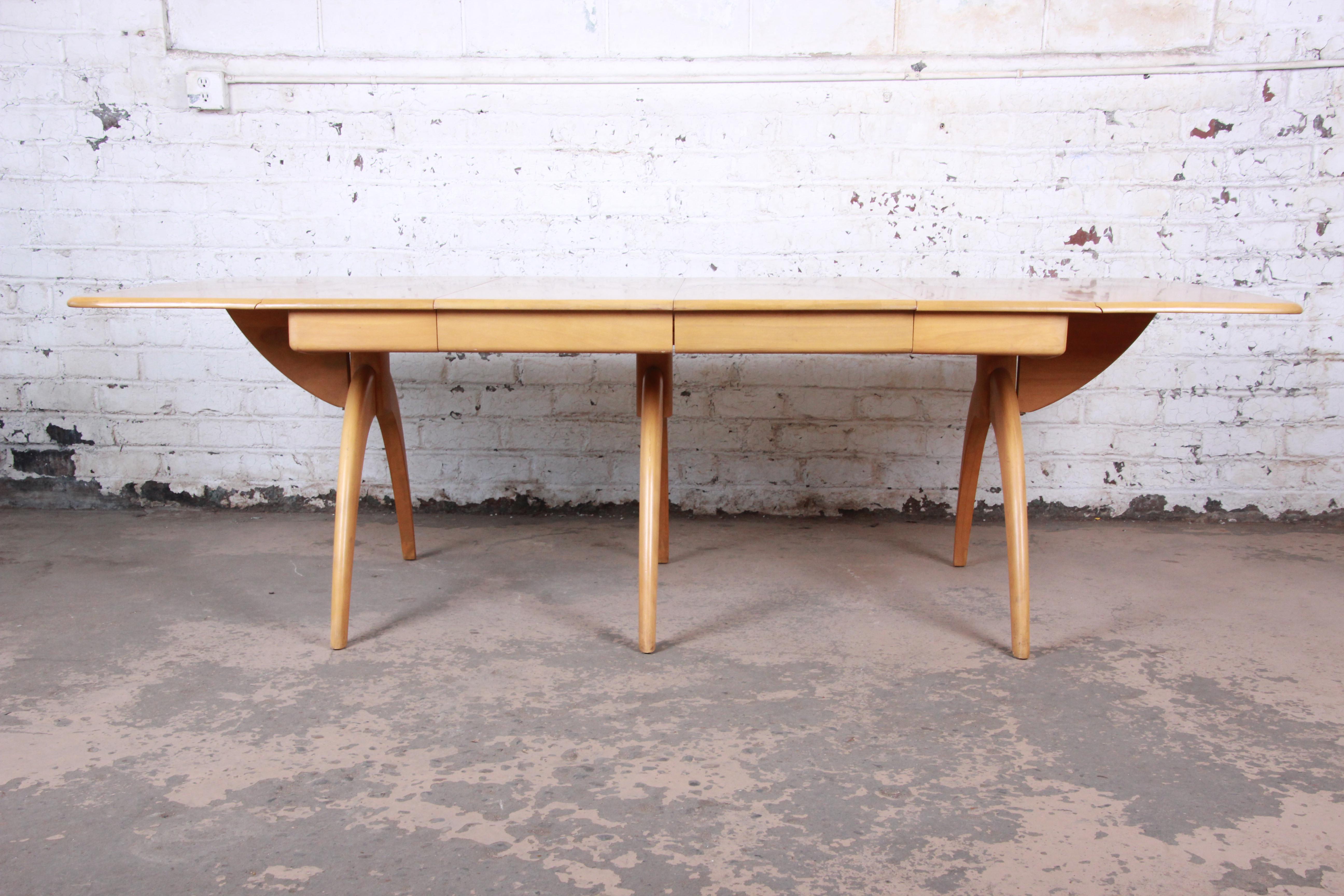 A gorgeous Mid-Century Modern extension drop-leaf wishbone dining table by Heywood-Wakefield. The table is well constructed from solid maple and features sculpted 