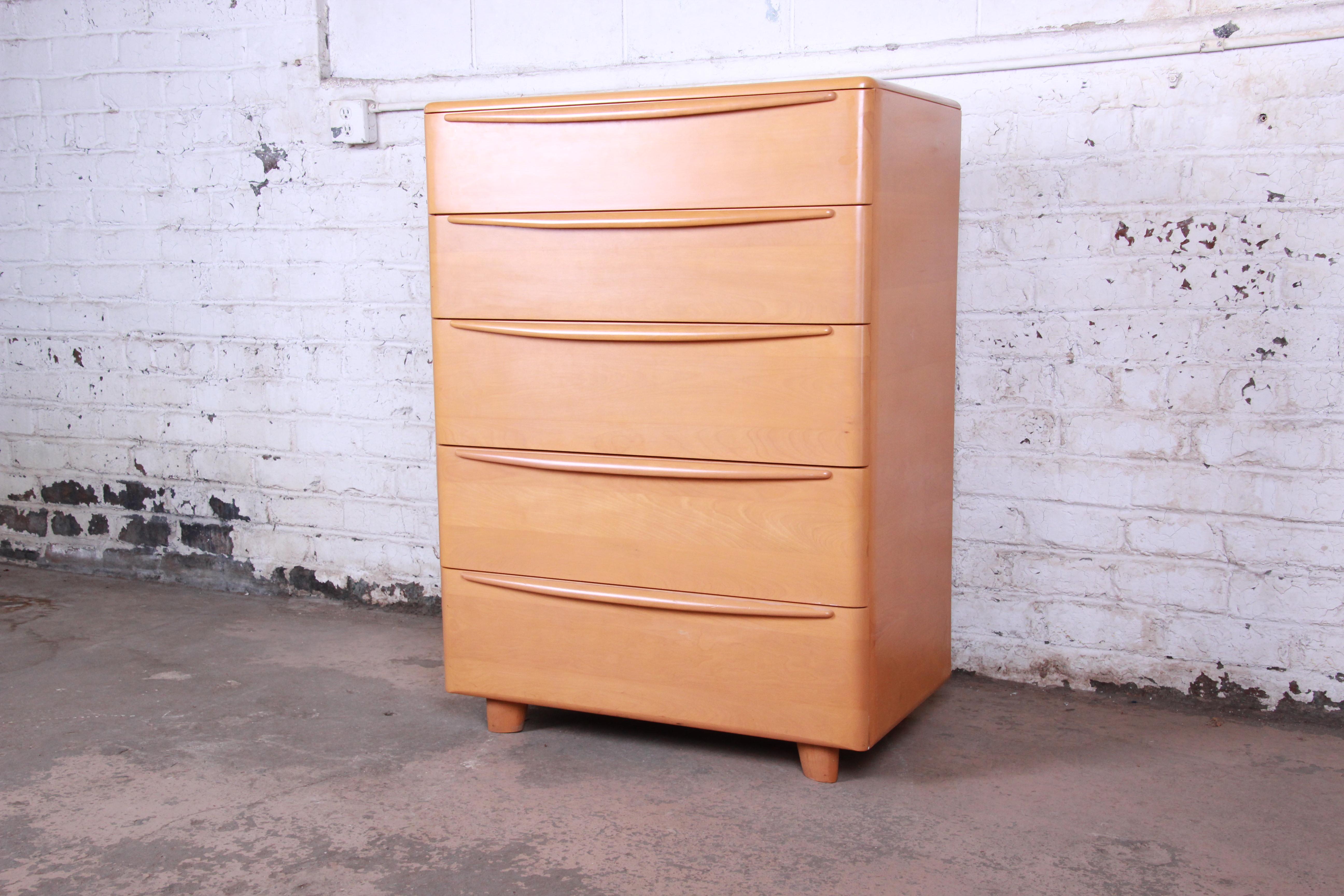 A very nice Mid-Century Modern highboy chest of drawers by Heywood Wakefield. The dresser features beautiful wood grain and solid birch construction. It offers ample storage with five large smooth sliding drawers with sculpted wood pulls. This