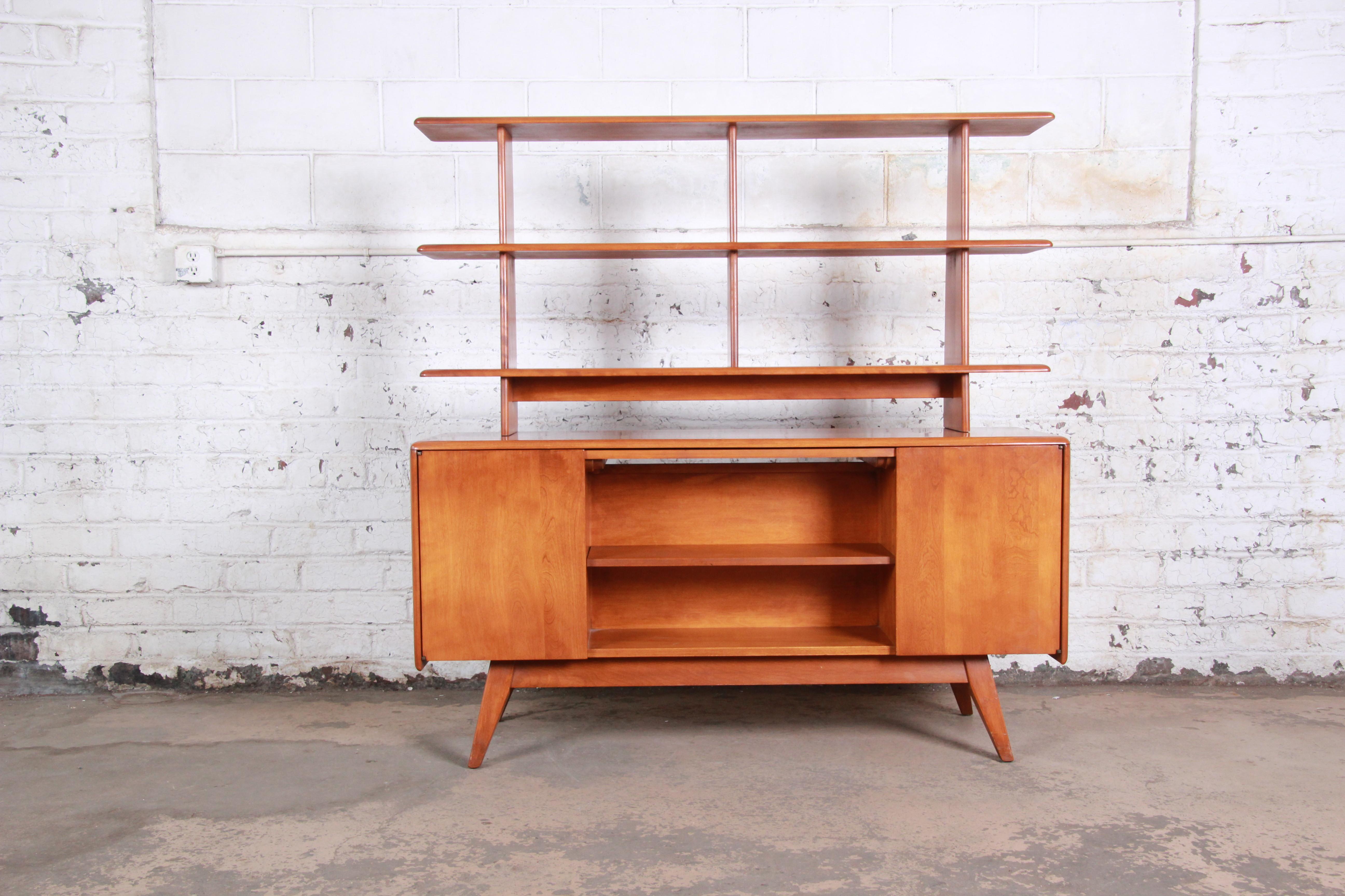 An extremely rare and exceptional Mid-Century Modern double sided room divider credenza by Heywood Wakefield. The room divider features solid maple construction and sleek midcentury lines. It offers ample storage, with two shelved cabinets and open