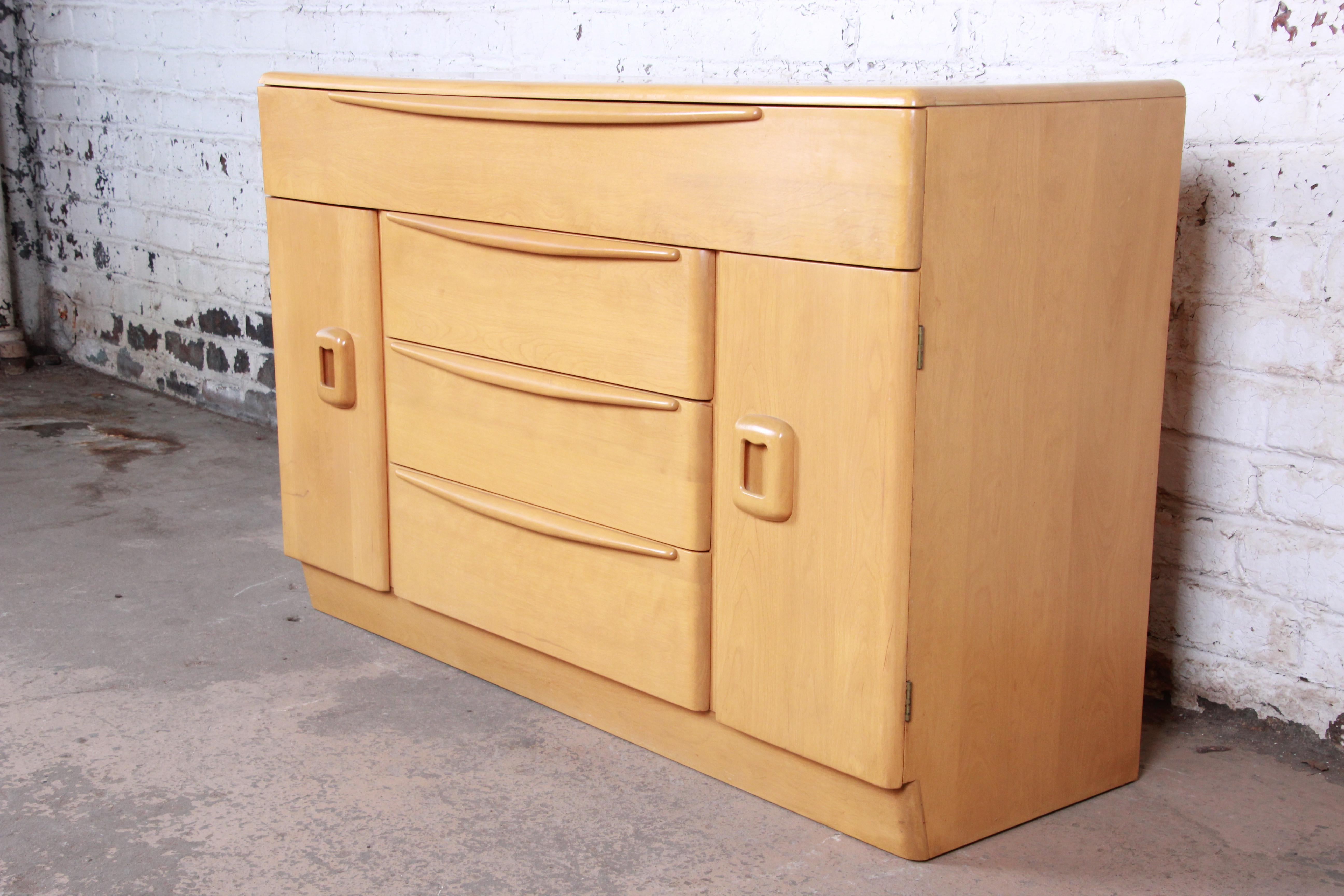 A very nice Mid-Century Modern sideboard or credenza by Heywood Wakefield. The sideboard features solid maple construction and sleek midcentury design. It offers ample storage, with a very long drawer at the top, three additional drawers in the