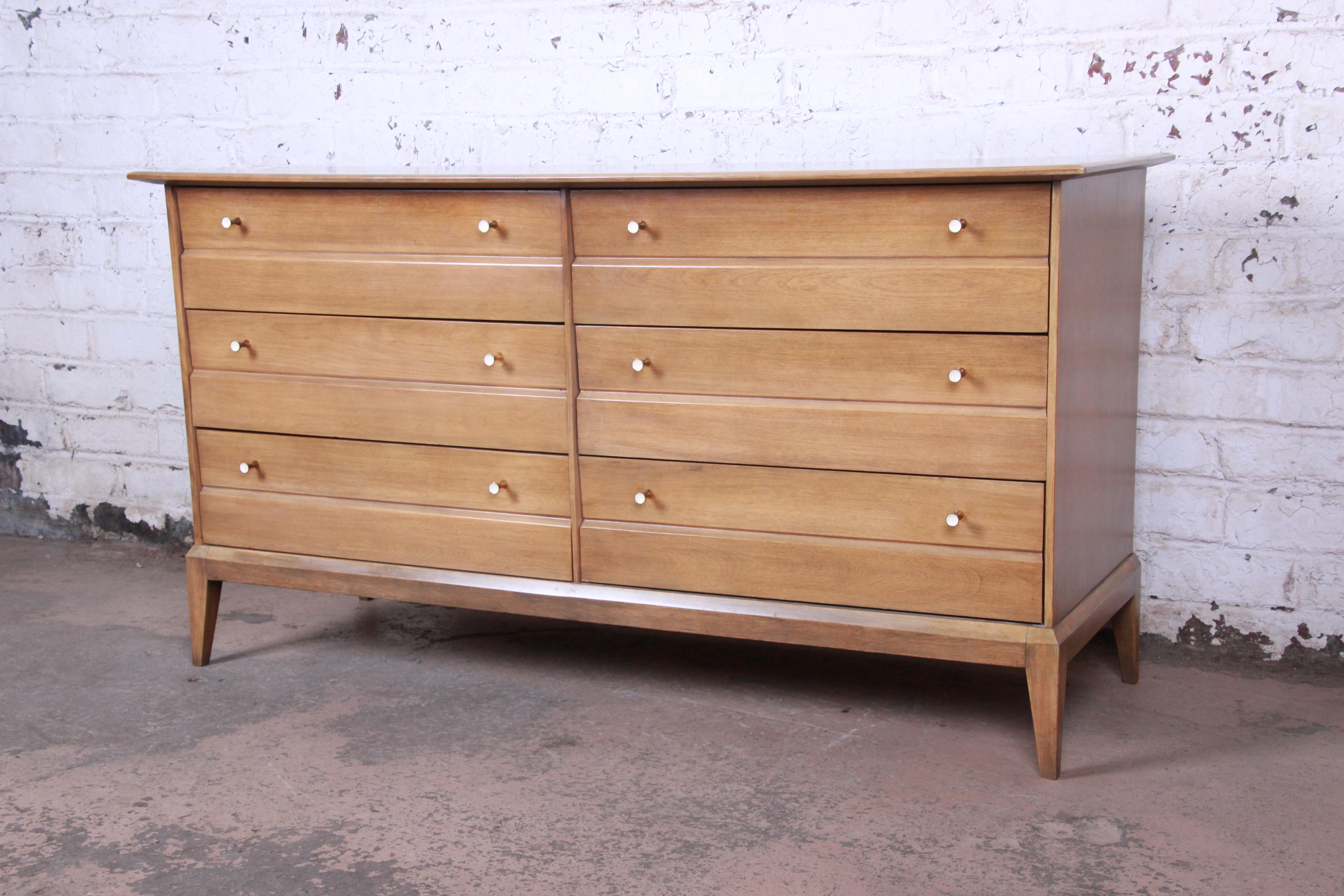 Offering a very nice intage six-drawer Mid-Century Modern dresser with mirror from the Cadence line by Heywood Wakefield. The dresser features clean, sleek Mid-Century design and solid maple construction in the 