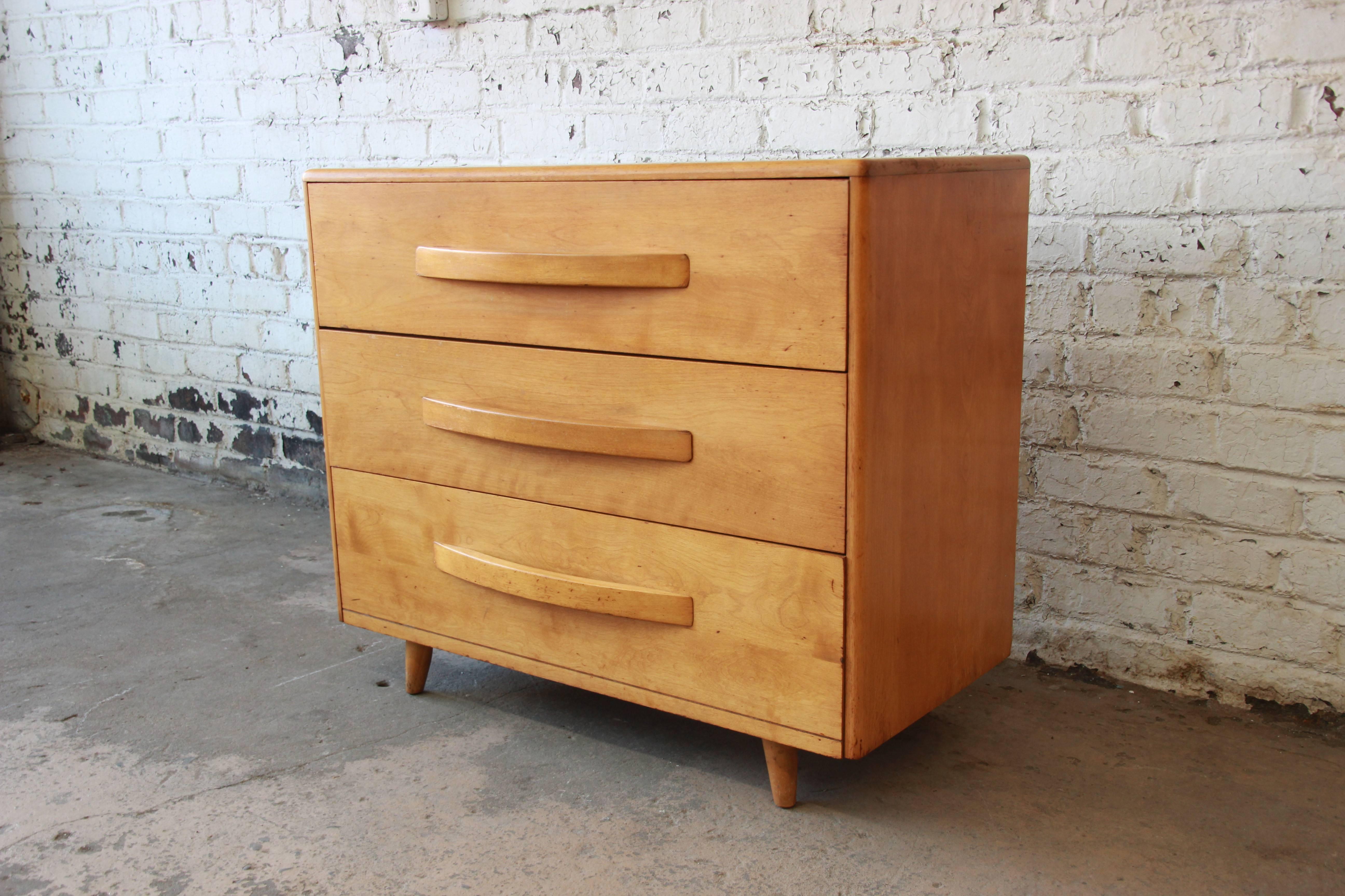 Offering a very nice Mid-Century Modern bachelor chest by Heywood Wakefield. The chest of drawers features solid birch wood construction and sleek mid-century design. It offers three deep drawers for storage, each with sculpted solid wood drawer