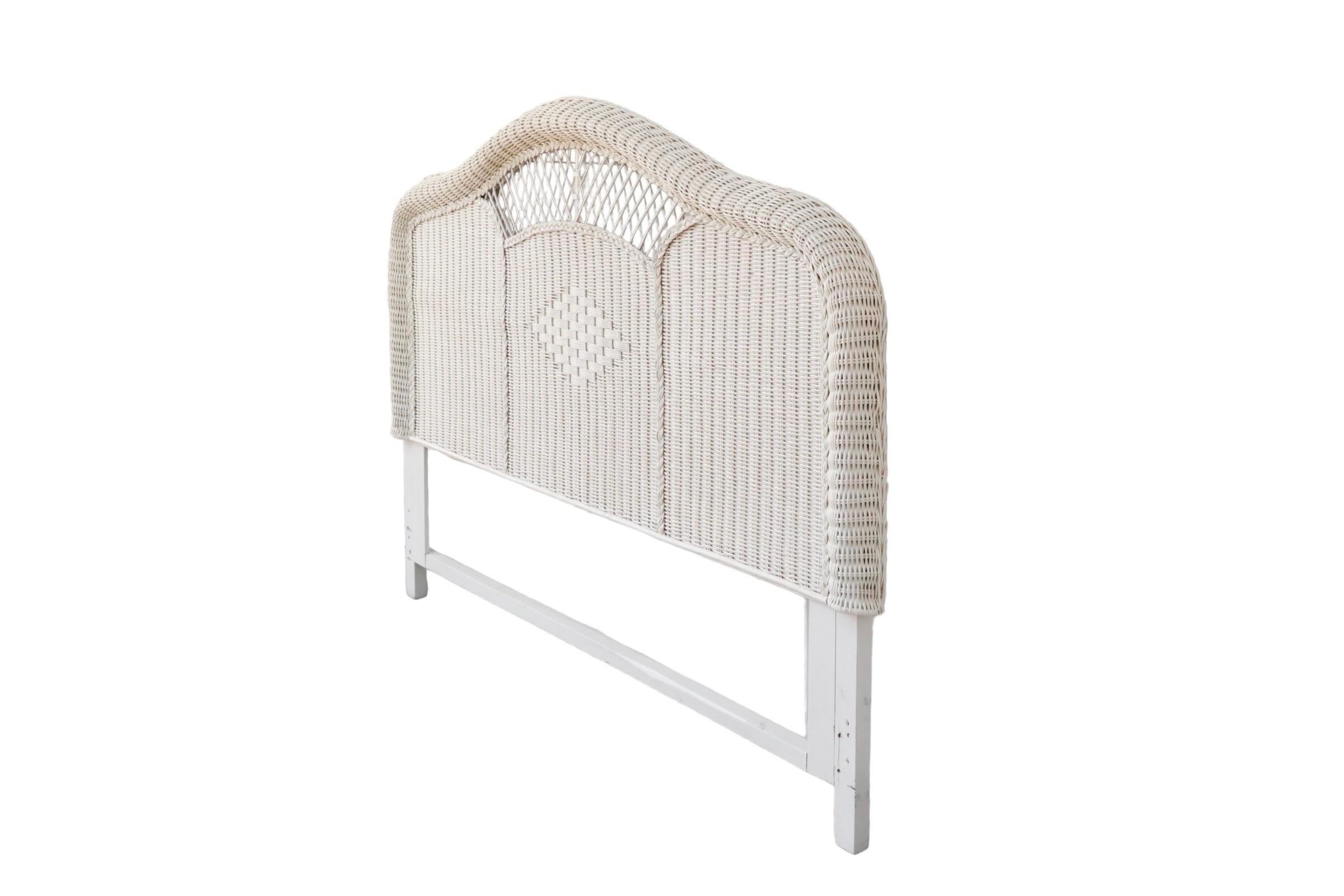 A Heywood Wakefield style queen size wicker headboard. A bentwood bamboo frame supports curved woven rattan in a camel back shape. Decorated with an open weave window above a traditional Heywood Wakefield style diamond. Finished throughout with a
