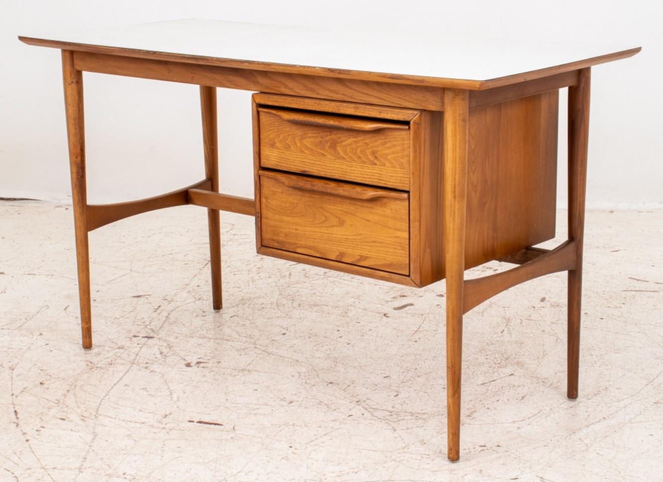 Heywood Wakefield Danish modern-style walnut small desk, circa 1960s with rectangular white formica top above two drawers to right. The four tapered legs are conjoined by stretchers. Manufacturers' branded mark is located in the top interior drawer.