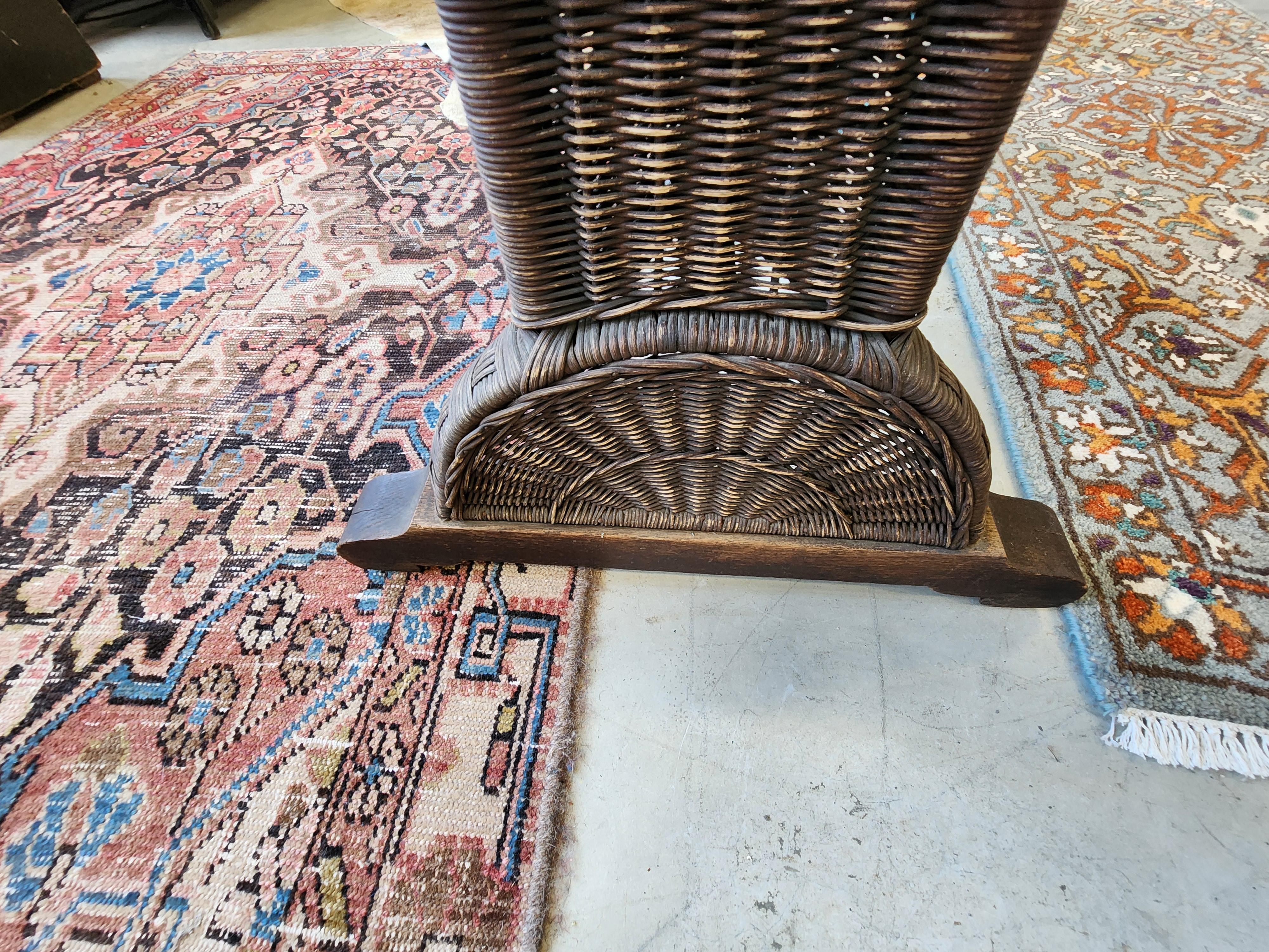 Heywood Wakefield library table. With quarter sawn, oak top and woven wicker pedestal legs, apron, and stretcher. This wicker table drew on the Aesthetic Movement and Japanese influences; simpler designs arose in the wake of the Arts and Crafts