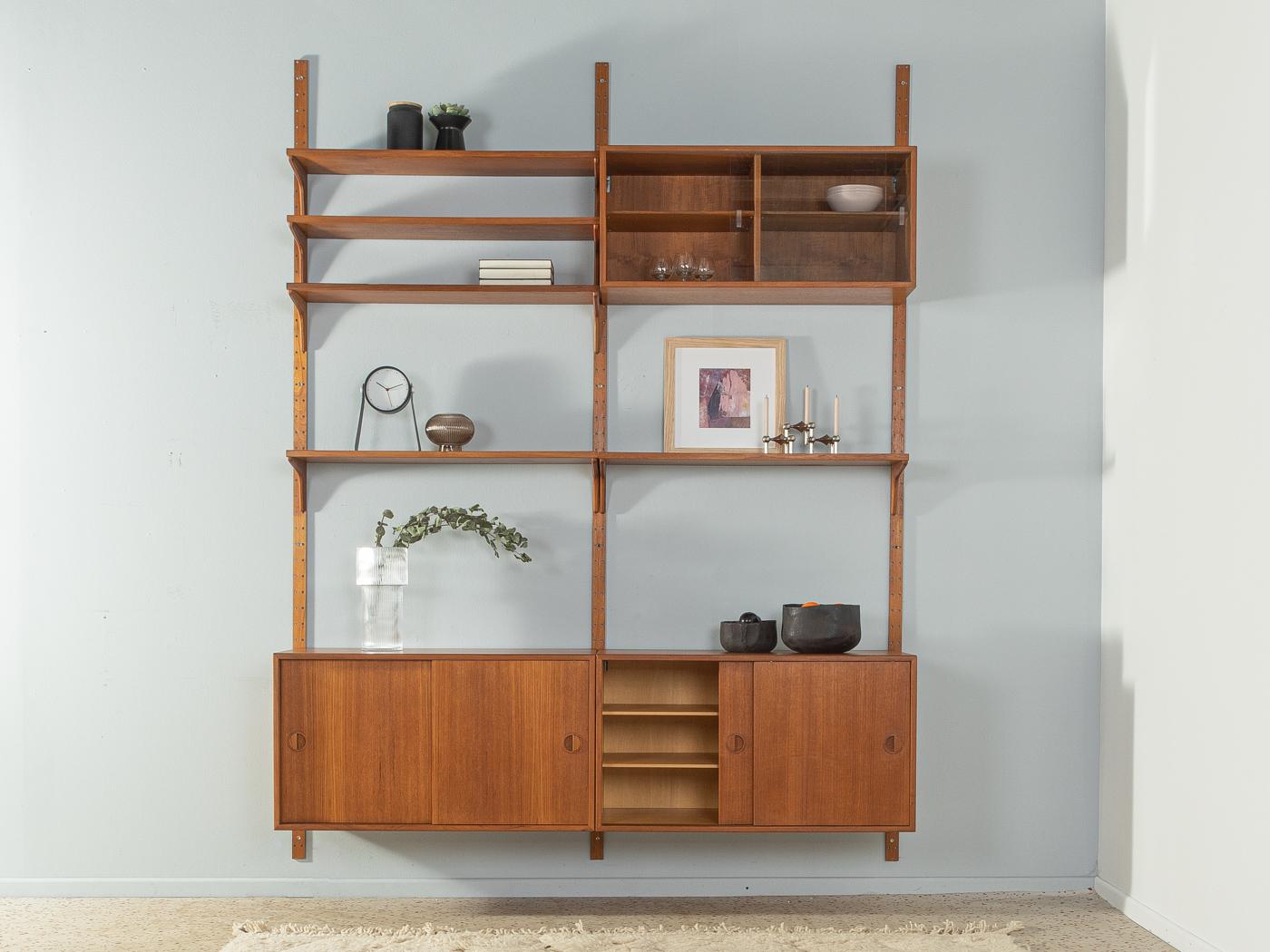 Classic shelving system from the 1960s by HG Furniture. The high-quality containers and shelves are veneered in teak. The system consists of one container with glass doors, two containers with sliding doors, five shelves and three