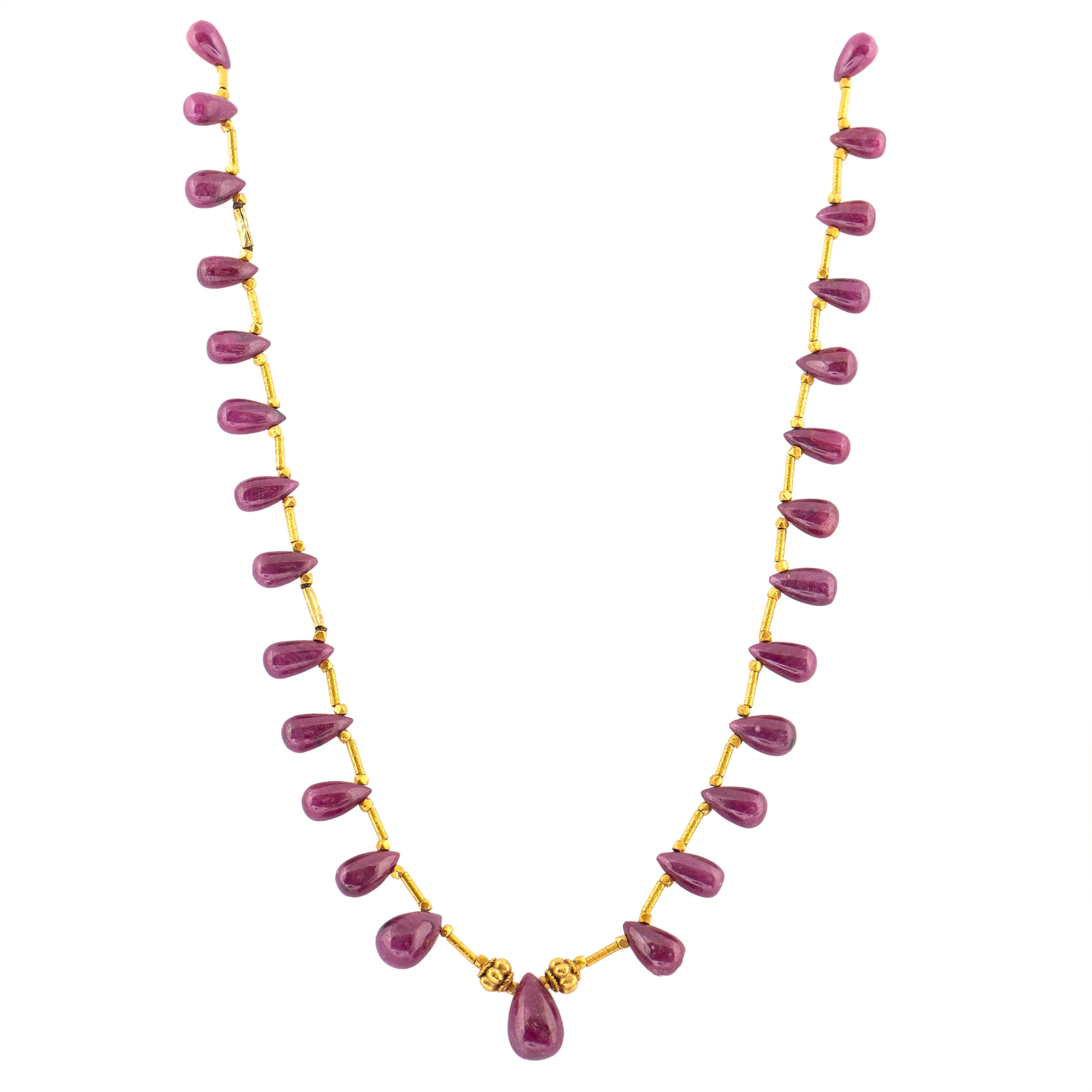 Hand made in the Etruscan style, designed as twenty eight ruby drops of rich deep raspberry colour, with a larger ruby drop in the center, enhanced by high karat gold link beads and tubular links, attached to a high carat gold custom made clasp.

15