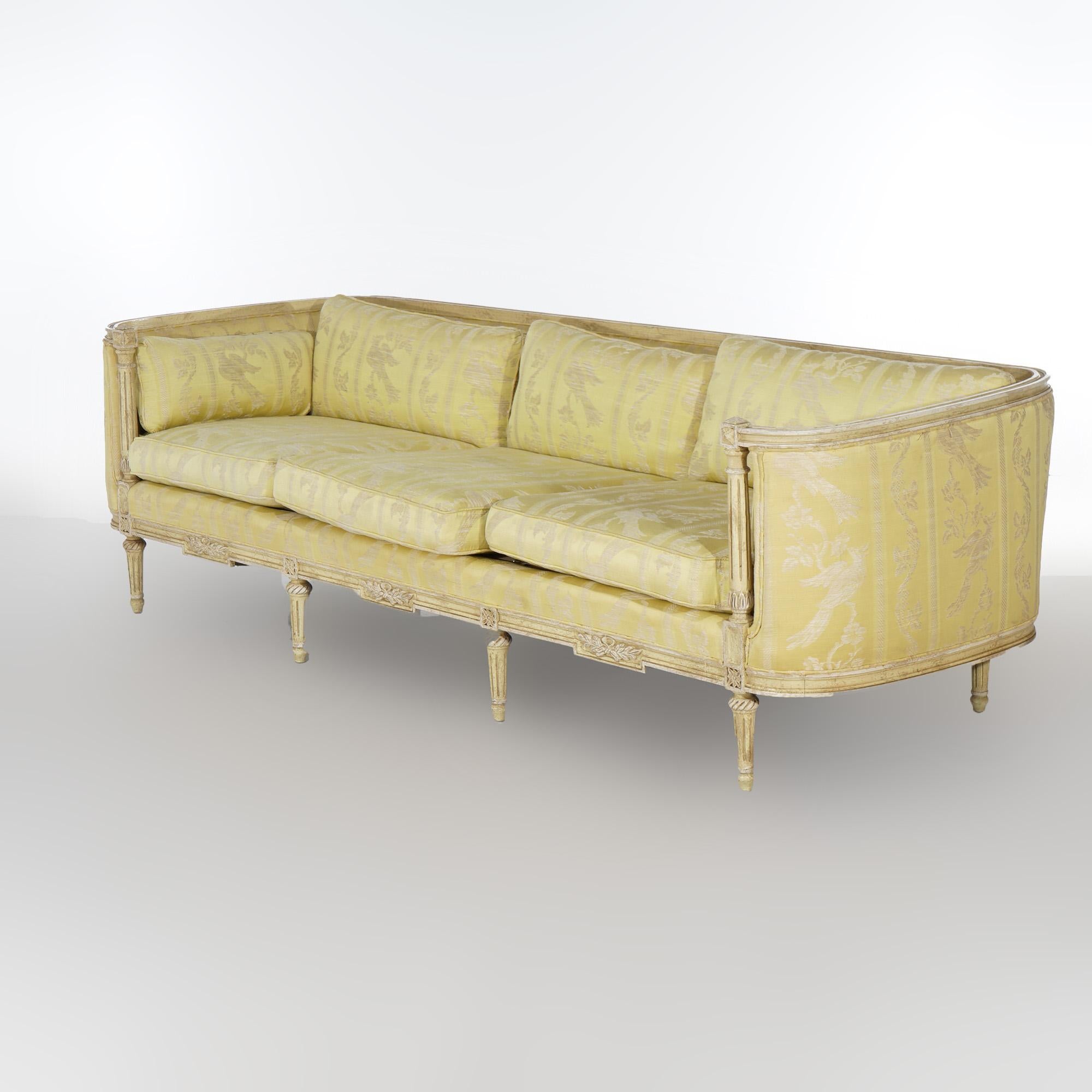 A French Louis XVI style sofa by Hibriten-Bernhardt offers wood frame in curved bergère form with upholstered upper having floral carved skirt and raised on tapered and reeded legs; maker label as photographed; 20th century

Measures - 27.5