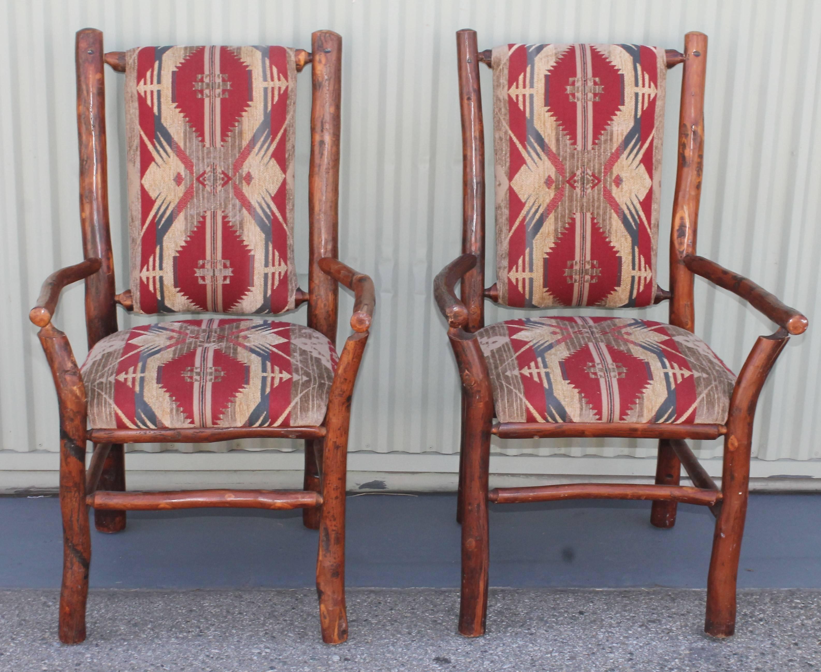 This pair of old hickory arm chairs are in good and sturdy condition. They are newly upholstered western vintage Indian design fabric. Very unusual chairs.