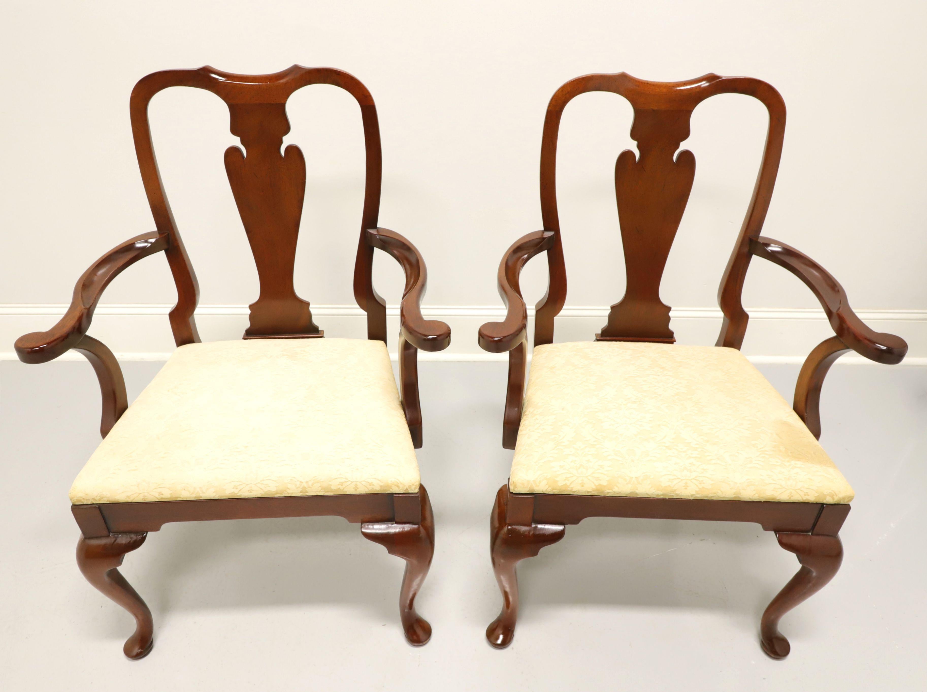 A pair of Queen Anne style dining armchairs by top quality furniture maker, Hickory Chair Company. Solid mahogany with their Amber Mahogany finish, carved back rest, curved arms, creamy gold color brocade fabric upholstered seat, cabriole front legs