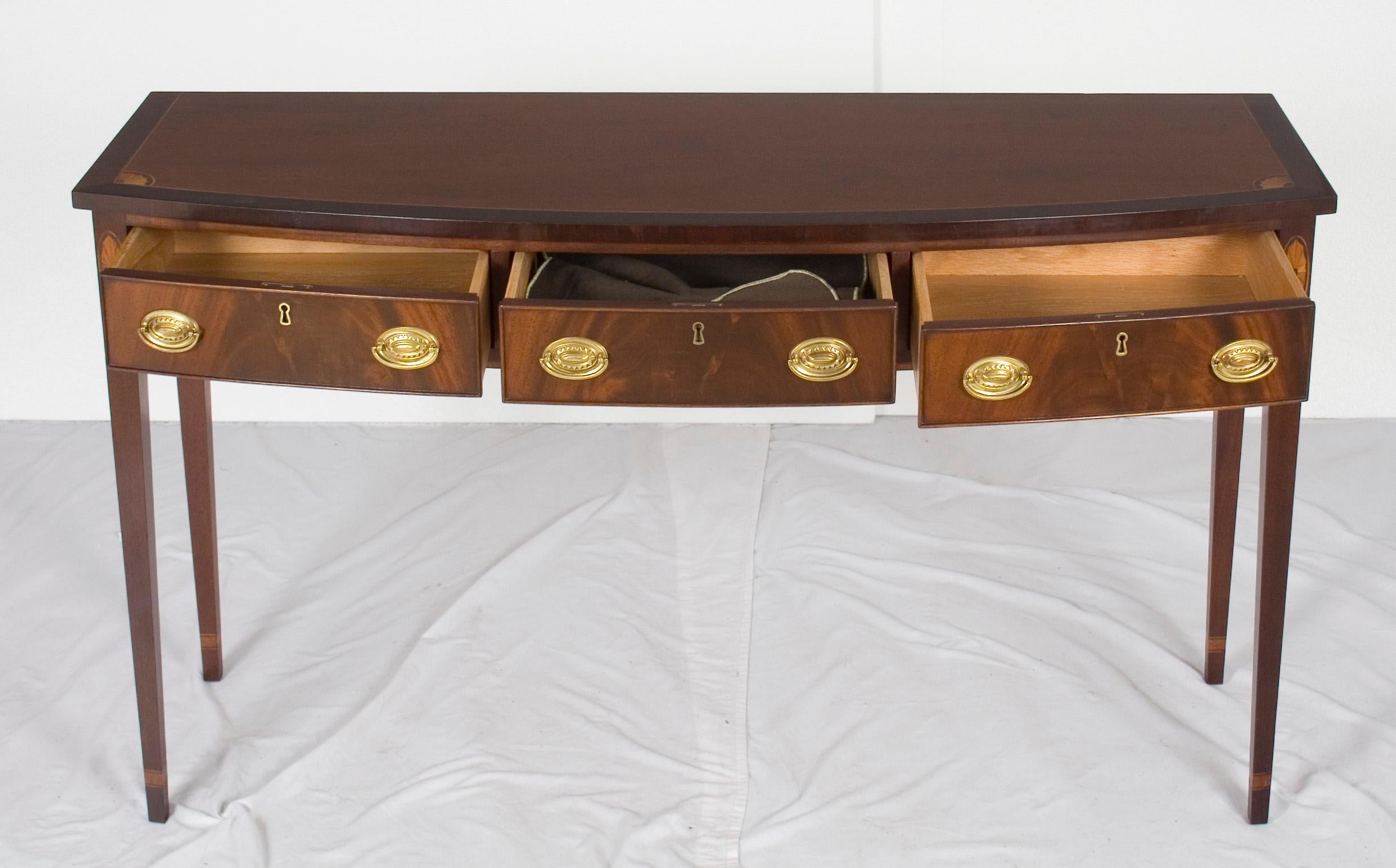 This stunning vintage bow front console table features gorgeous mahogany wood. The relatively small size makes it perfect for a variety of places in the home. It makes a wonderful small buffet, sofa table, or console table in a foyer.

 Inside, on