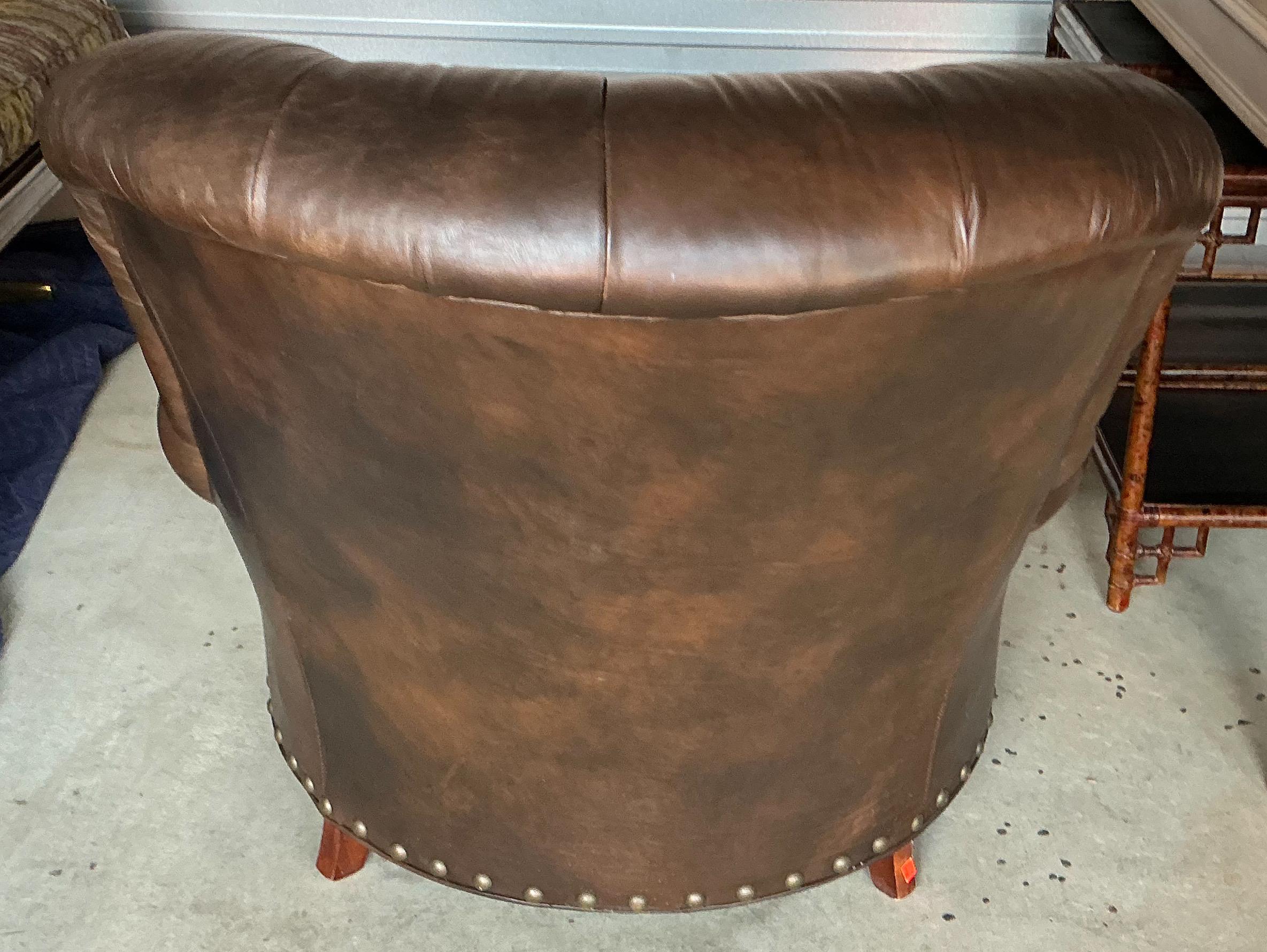This is a handsome pair of Chesterfield style tufted leather club chairs by Hickory Chair. The leather is a rich dark brown. They have turned wooden bun feet. The chairs are marked and in very good condition.
