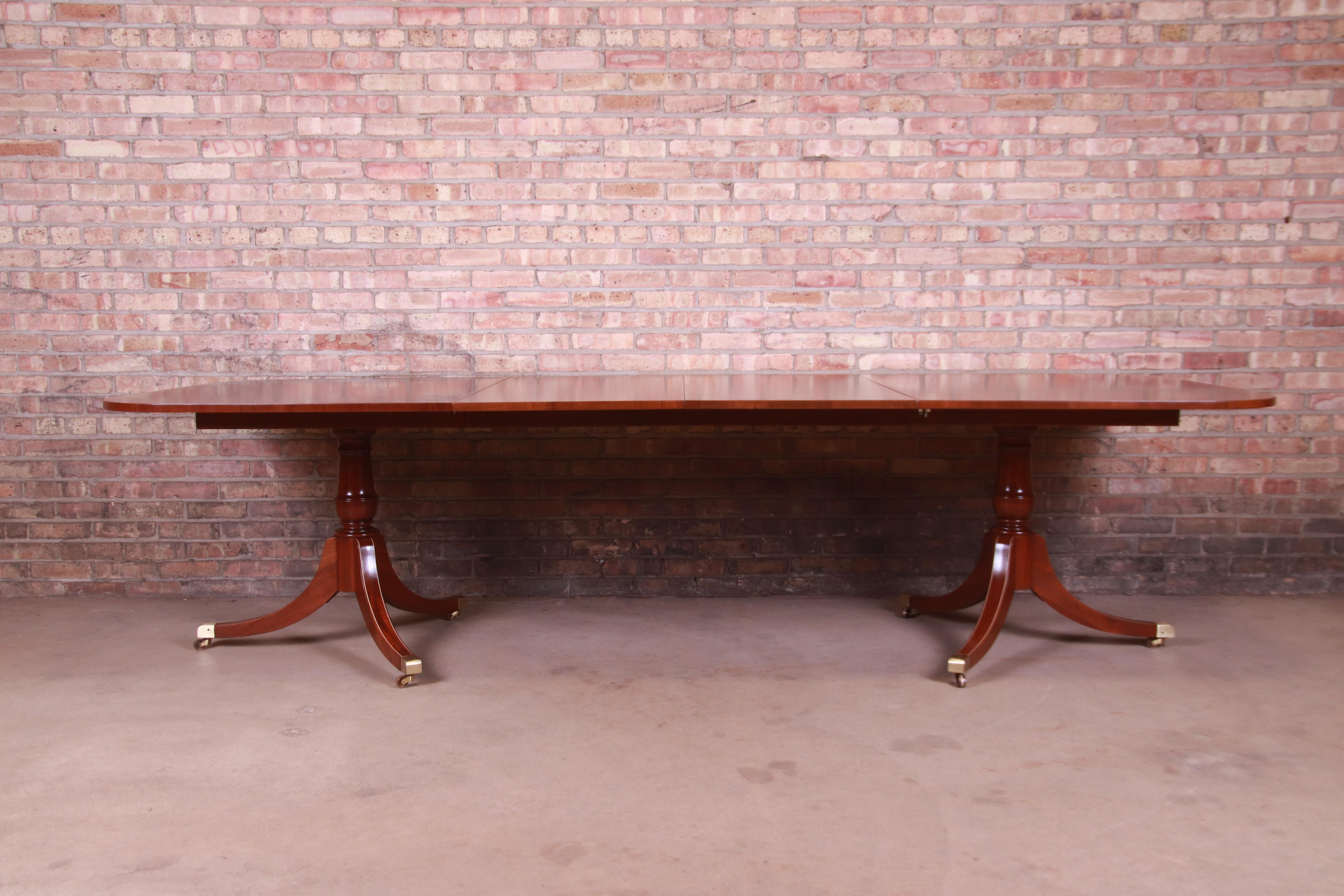 An exceptional Georgian style double pedestal extension dining table

By Hickory Chair Furniture Company

USA, late 20th century

Book-matched mahogany, with carved solid mahogany pedestals and brass-capped feet.

Measures: 72.13