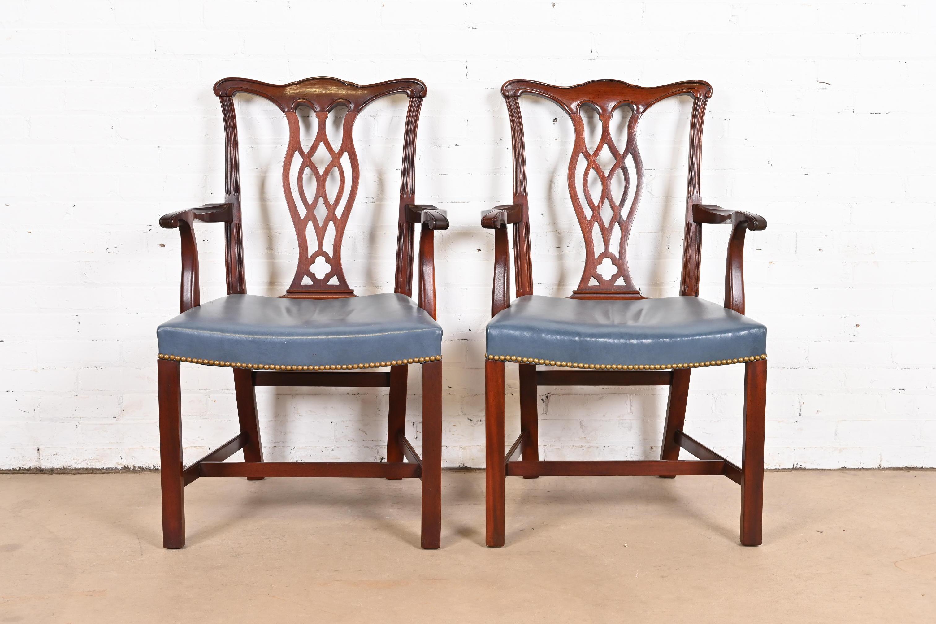 A gorgeous pair of Georgian or Chippendale style dining arm chairs

By Hickory Chair Furniture Co.

USA, Circa 1980s

Carved mahogany, with brass studded blue leather seats.

Measures: 24.25