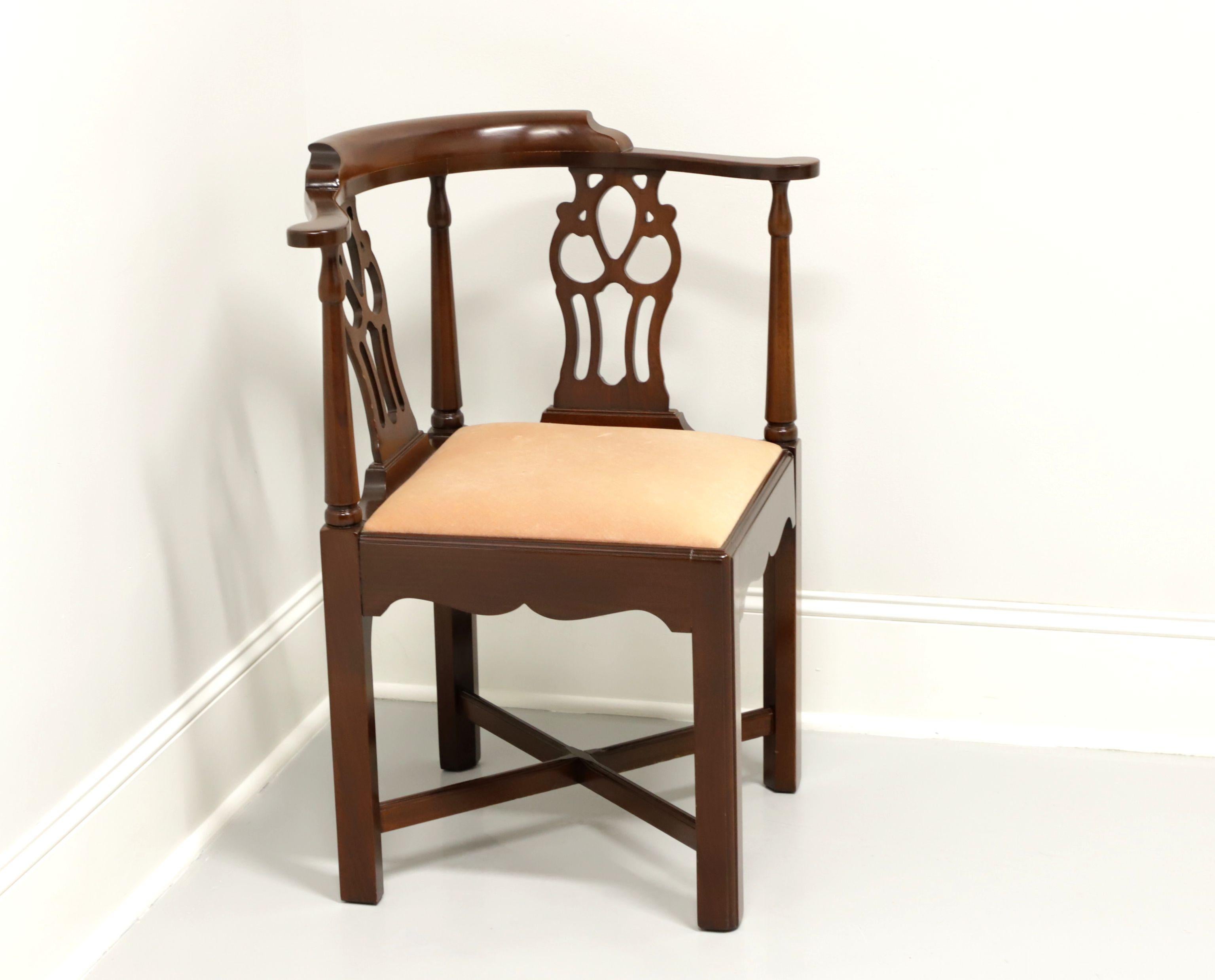 A Georgian style corner chair by high-end furniture maker Hickory Chair Company of Hickory, North Carolina, USA. Solid mahogany, carved backrest, salmon color velvet like fabric upholstered seat, stretchers and straight legs. Made in the late 20th