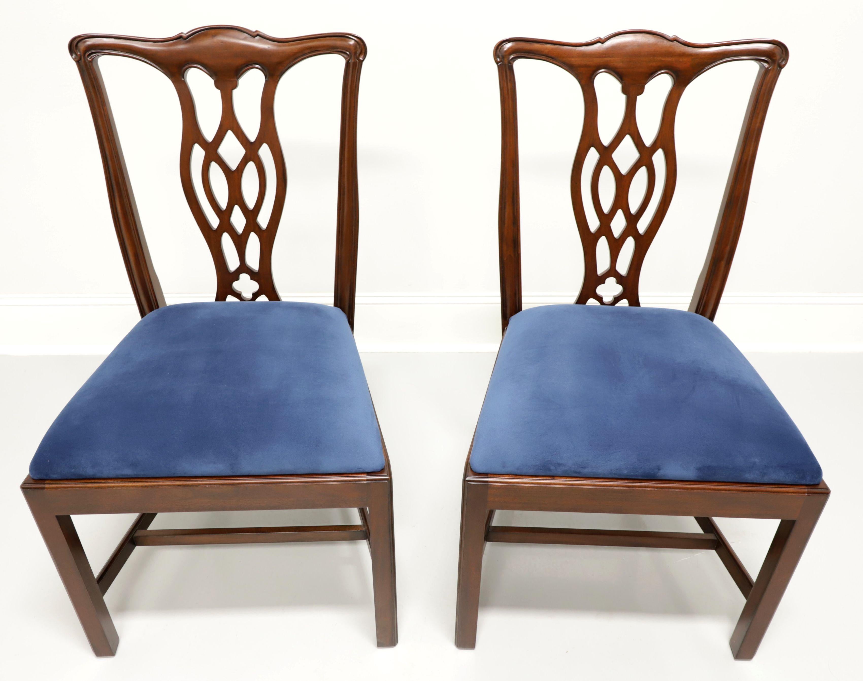 A pair of dining side chairs in the Chippendale style by Hickory Chair Company. Solid mahogany with carved crestrail, carved seat back, blue color crushed velvet upholstered seat, straight legs and stretchers. Made in North Carolina, USA, in the