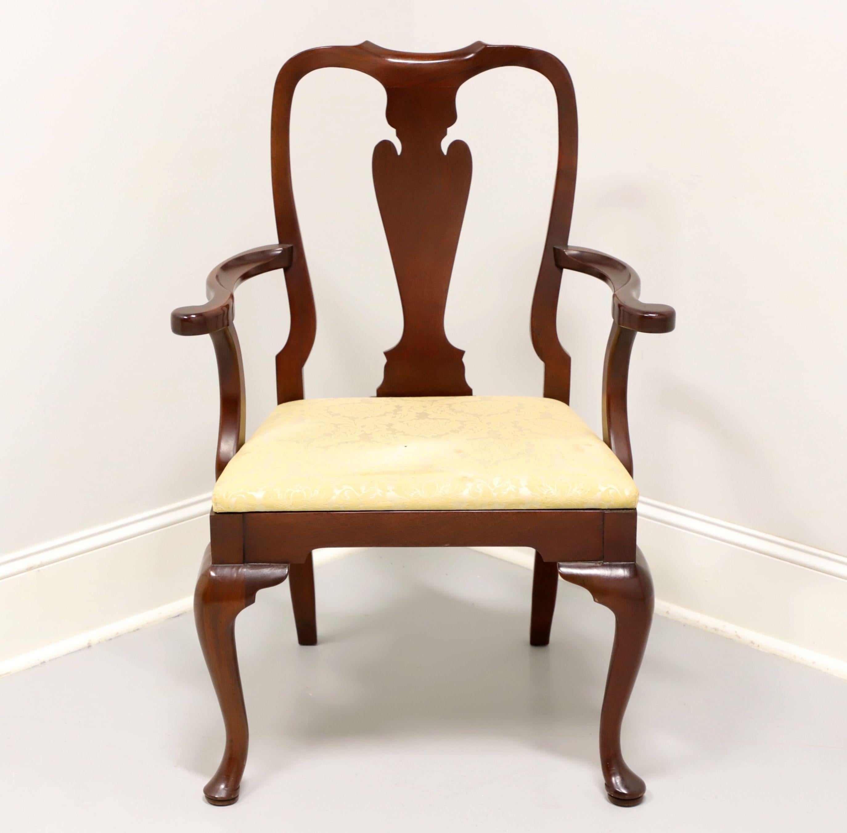 A Queen Anne style dining armchair by Hickory Chair. Mahogany with solid carved back, curved arms with arched supports, a creamy yellow fabric upholstered seat, cabriole legs and pad feet. Made in North Carolina, USA, in the late 20th