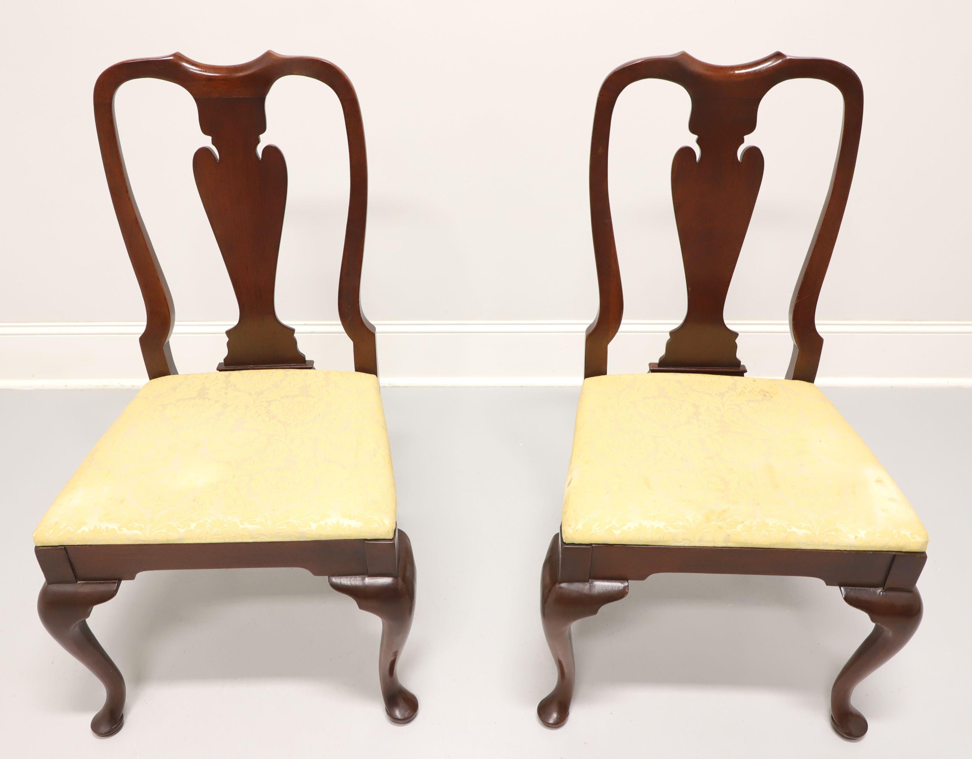 A pair of Queen Anne style dining side chairs by Hickory Chair. Mahogany with solid carved back, a creamy yellow fabric upholstered seat, cabriole legs and pad feet. Made in North Carolina, USA, in the late 20th century.

Measures: Overall: 22.25w