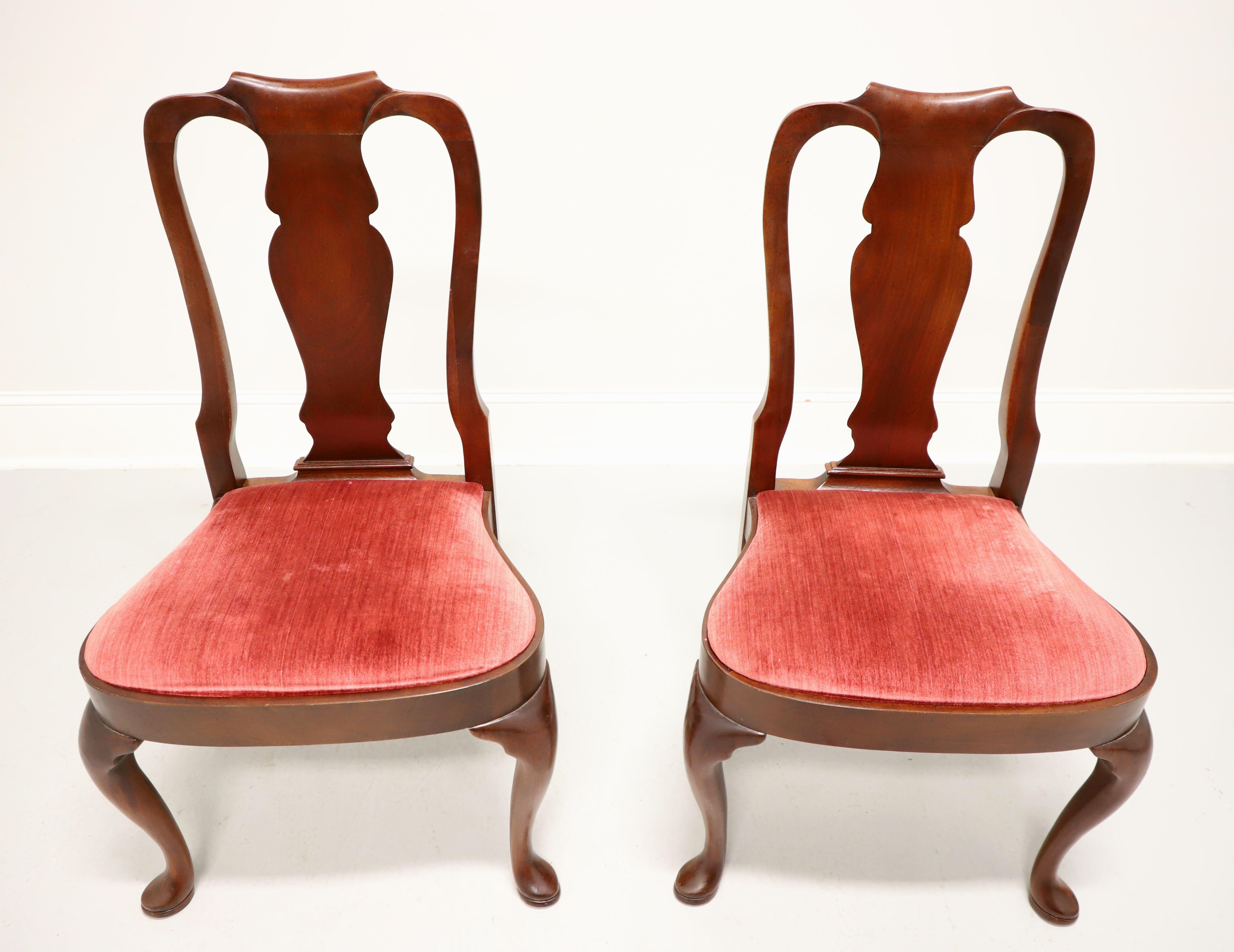 A pair of Queen Anne style dining side chairs by high-quality furniture maker Hickory Chair. Mahogany with solid carved back rest, a rose red color velvet fabric upholstered seat, rounded apron, cabriole legs and pad feet. Made in North Carolina,