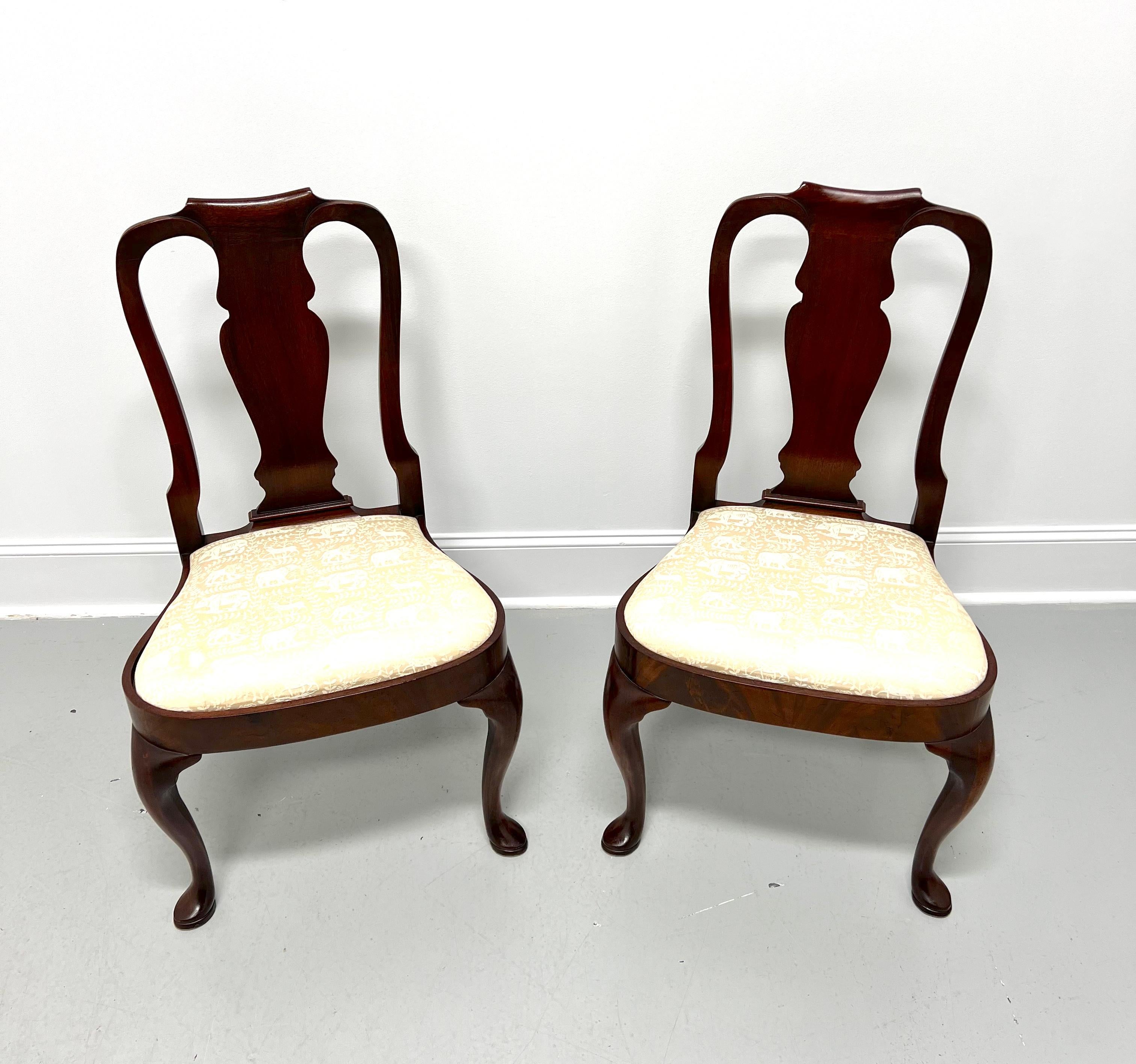 A pair of Queen Anne style dining side chairs by Hickory Chair. Mahogany with carved backrest, a cream color brocade fabric upholstered seat, rounded apron, cabriole front legs, and pad feet. Made in North Carolina, USA, in the late 20th