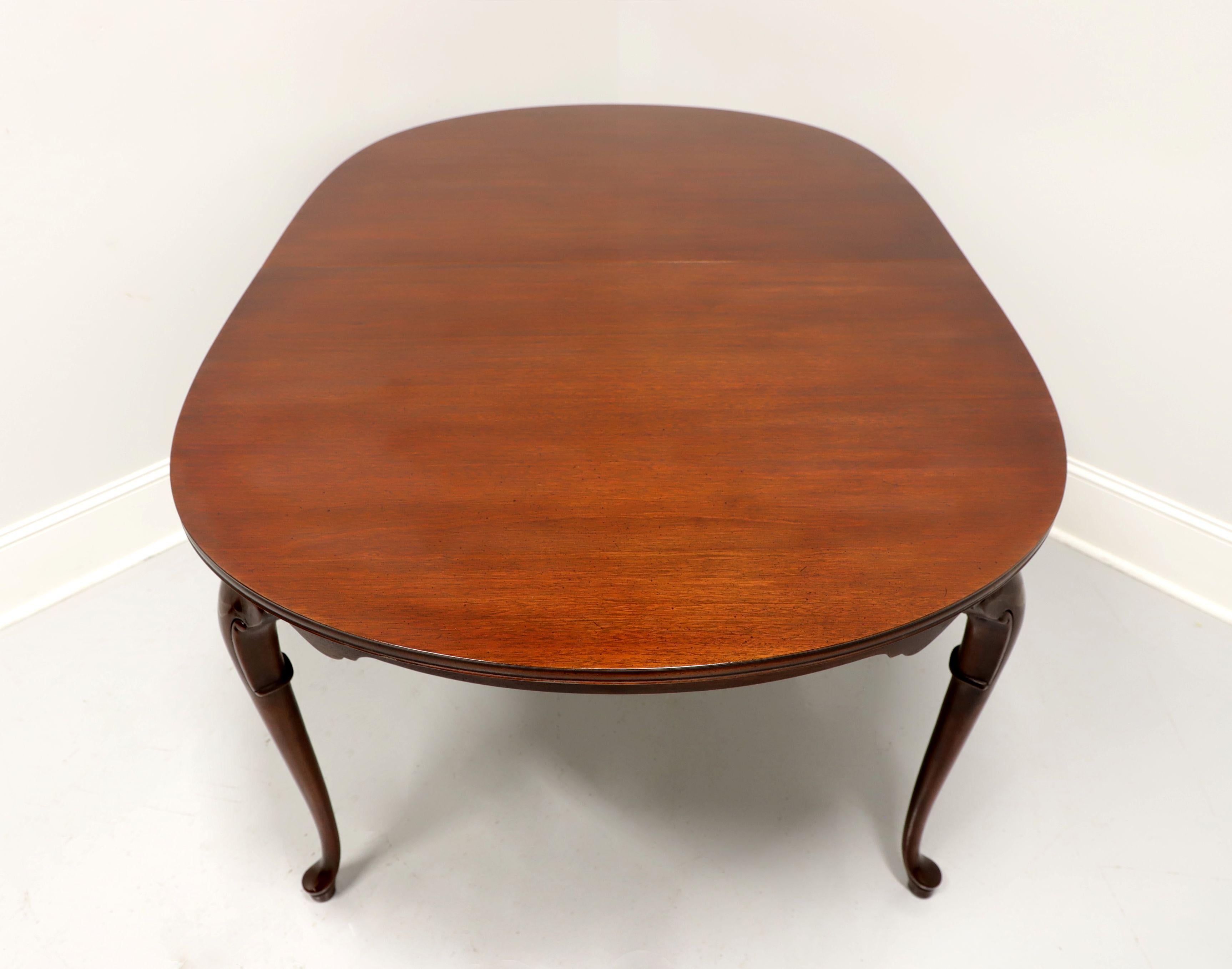 A Queen Anne style oval dining table by high-quality furniture maker Hickory Chair. Mahogany with solid top, carved apron, decorative knees, cabriole legs and pad feet. Metal expansion sliders. Includes two extension leaves. Made in the USA, in the