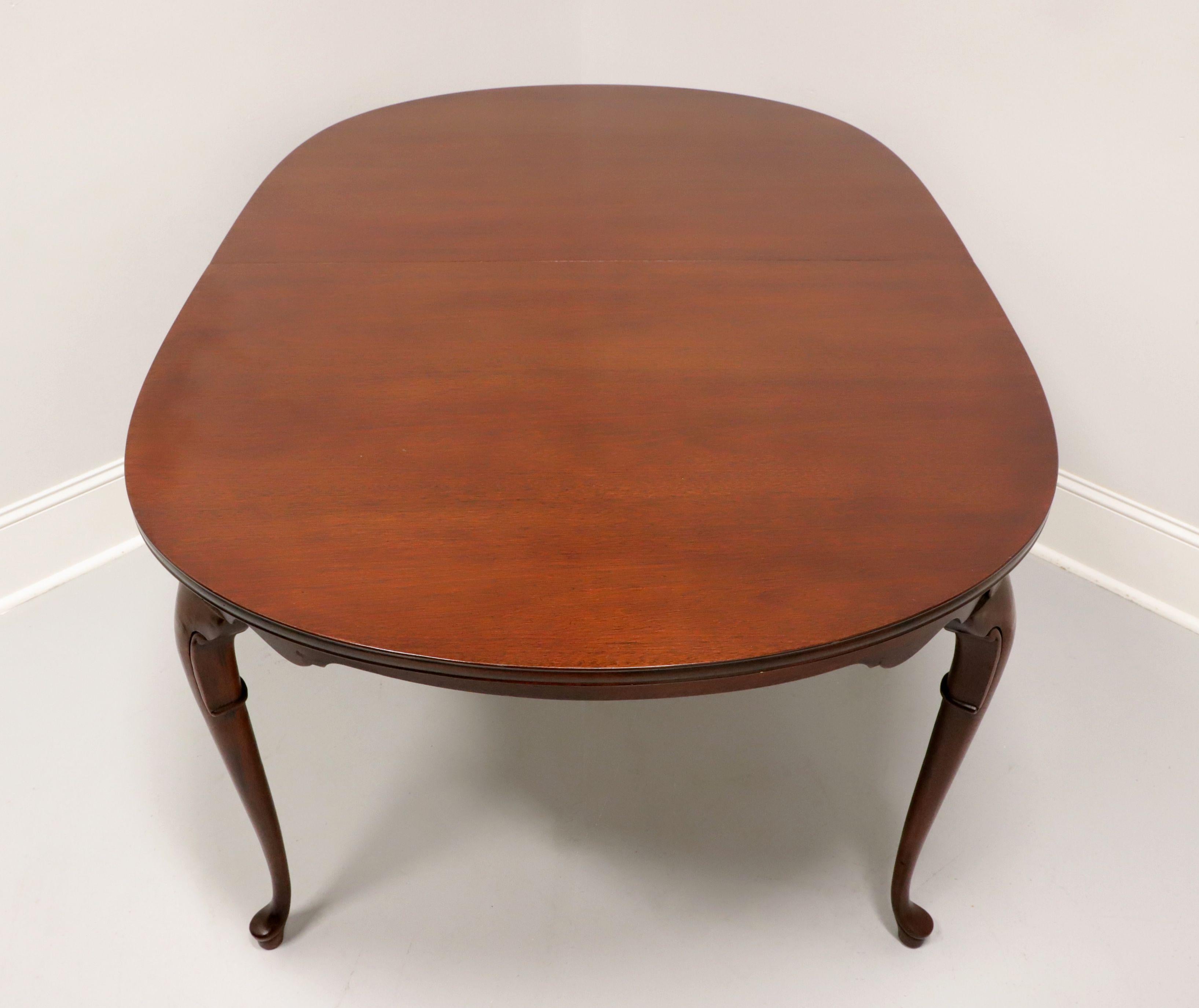 A Queen Anne style oval dining table by high-quality furniture maker Hickory Chair. Mahogany with solid edge to the top, carved apron, decoratively carved knees, cabriole legs and pad feet. Includes two 18 inch extension leaves for placement on