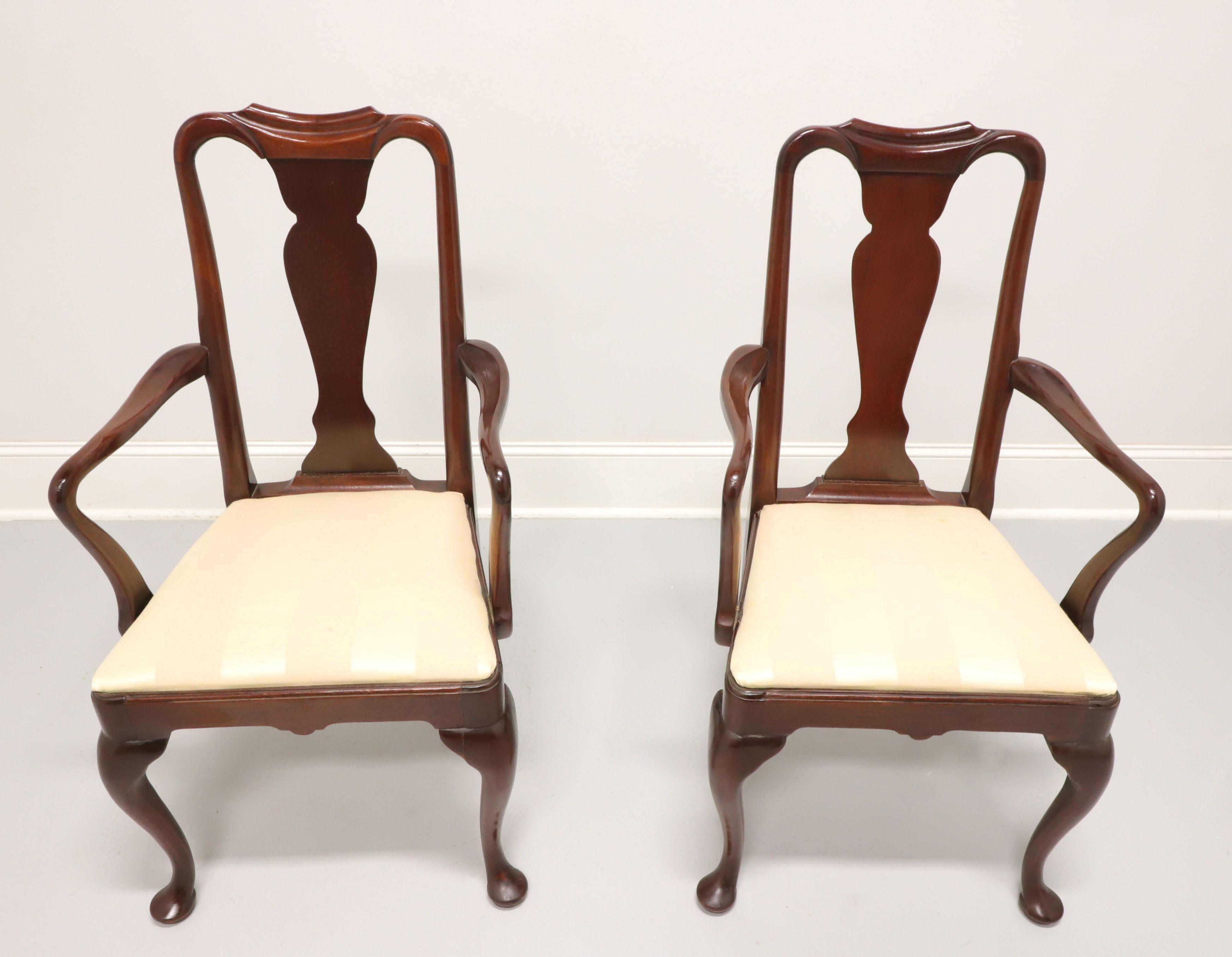 A pair of dining armchairs in the Queen Anne style by Hickory Chair. Solid mahogany with solid carved back, curved arms & supports, a yellow/gold color stripe fabric upholstered seat, cabriole legs and pad feet. Made in North Carolina, USA, in the