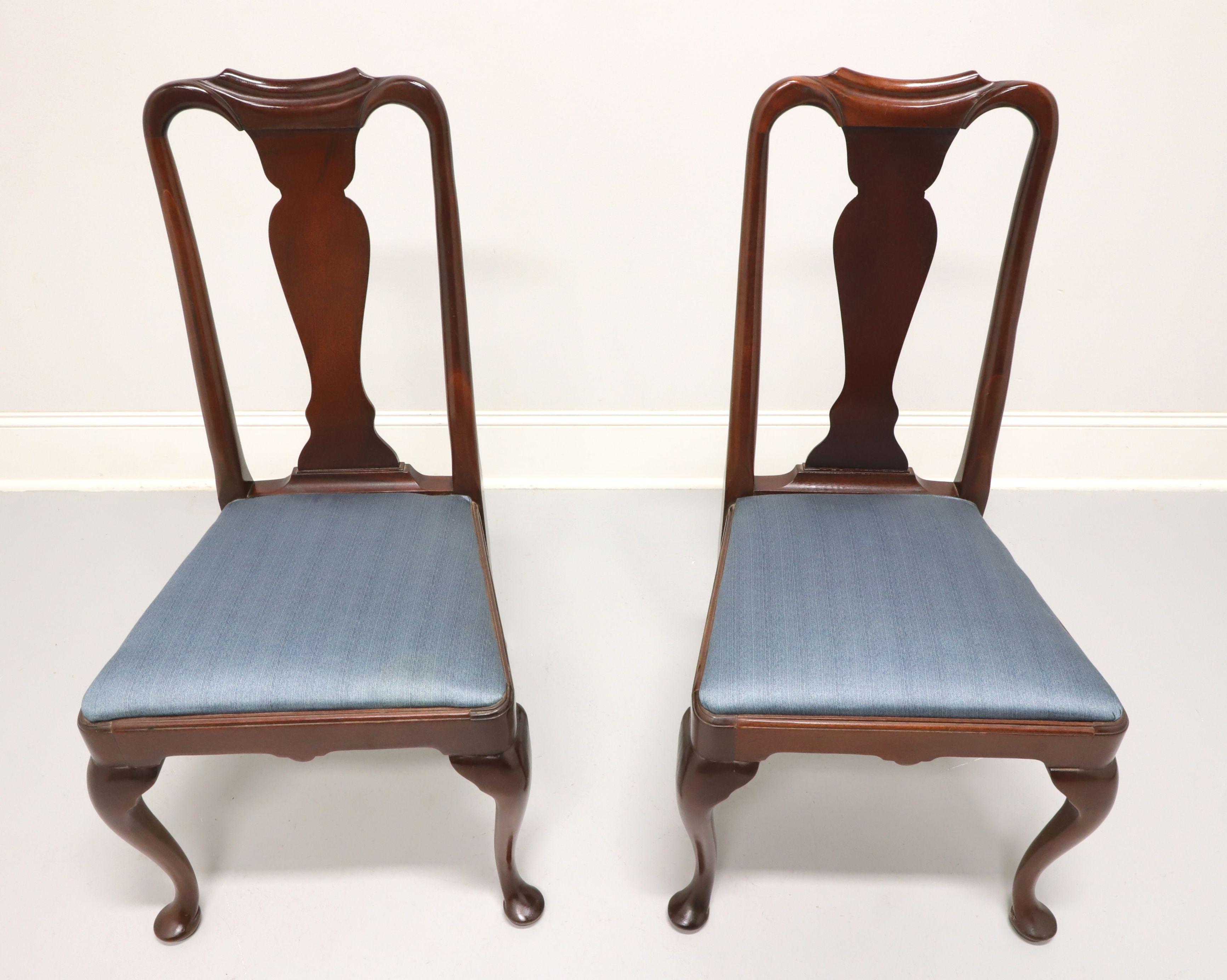 A pair of dining side chairs in the Queen Anne style by Hickory Chair. Solid mahogany with solid carved back, a blue color fabric upholstered seat, cabriole legs and pad feet. Made in North Carolina, USA, in the late 20th century.

Measures: