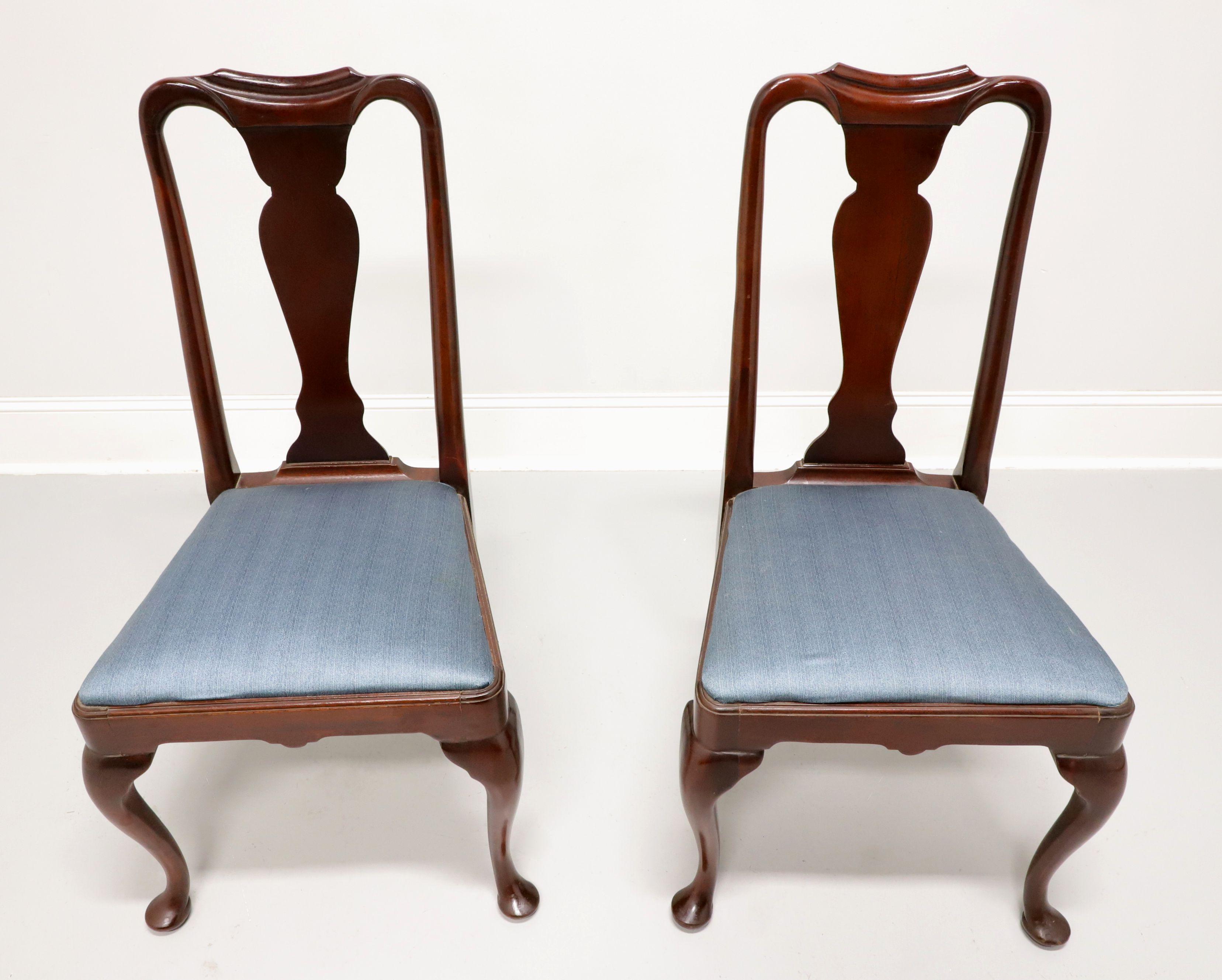 A pair of dining side chairs in the Queen Anne style by Hickory Chair. Solid mahogany with solid carved back, a blue color fabric upholstered seat, cabriole legs and pad feet. Made in North Carolina, USA, in the late 20th century.

Measures: