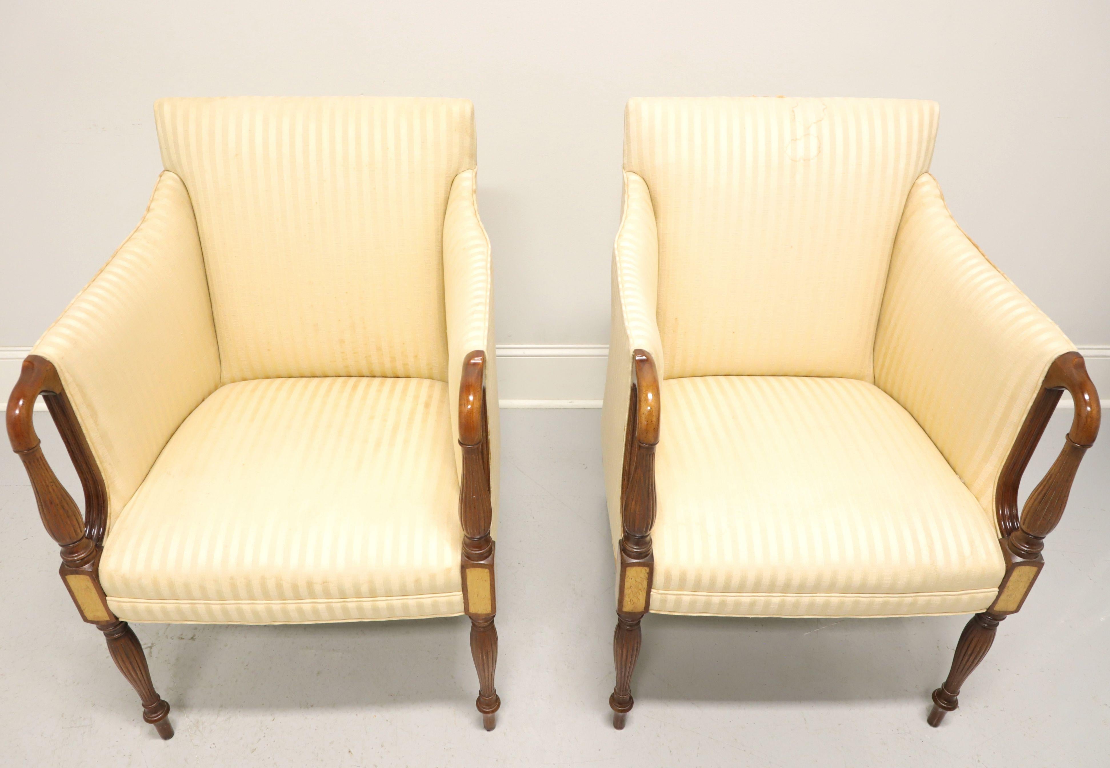 A pair of Sheraton style upholstered armchairs by Hickory Chair. Walnut with lighter color inlays to knees, curved & fluted open arms, cream color damask fabric upholstery and fluted front legs. Ready for you to have reupholstered in a fabric to