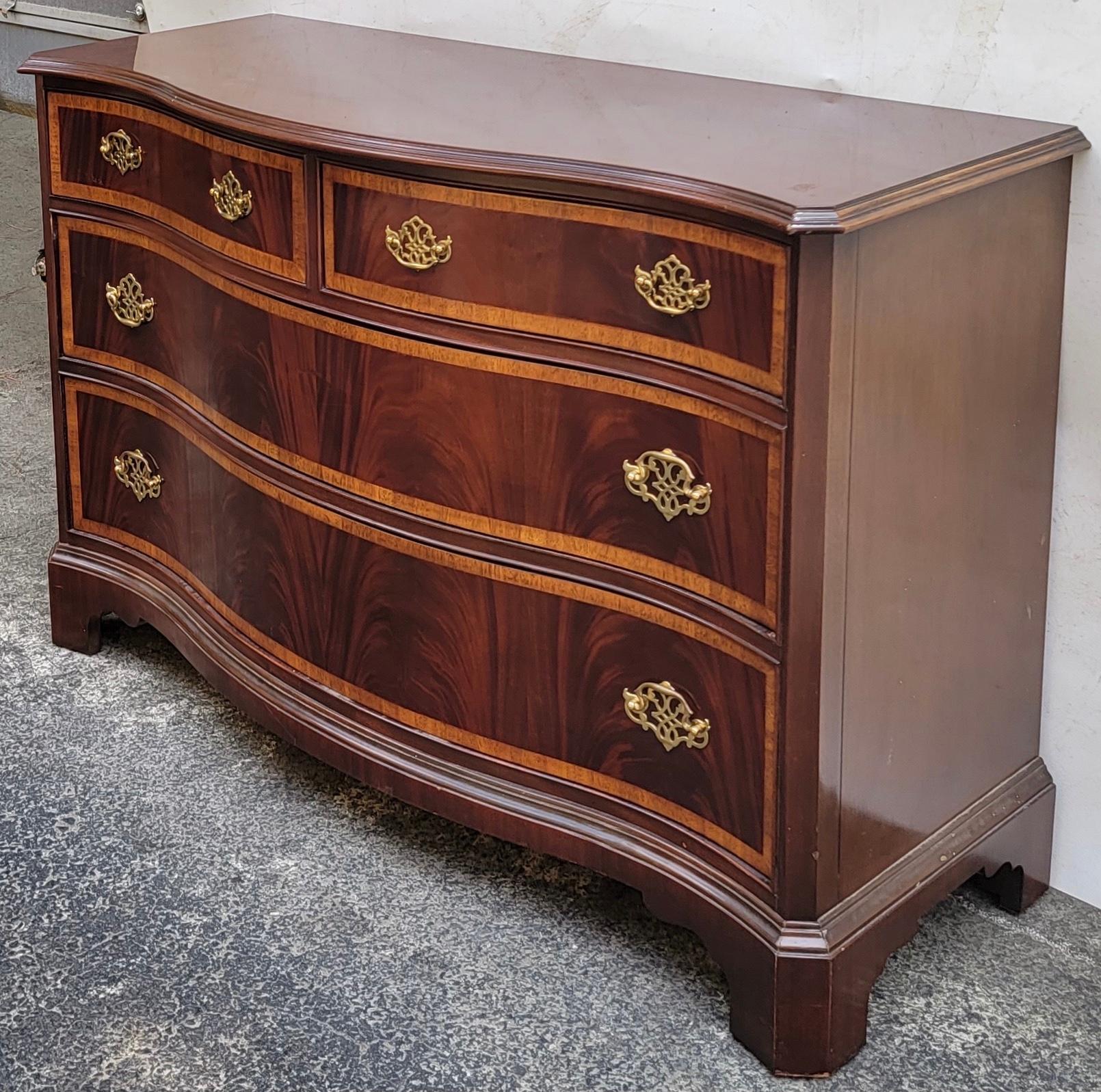 This Chinese Chippendale flame mahogany and satinwood banded serpentine chest is by Hickory Furniture. Ithas timeless elegance and is in very good condition It is marked.